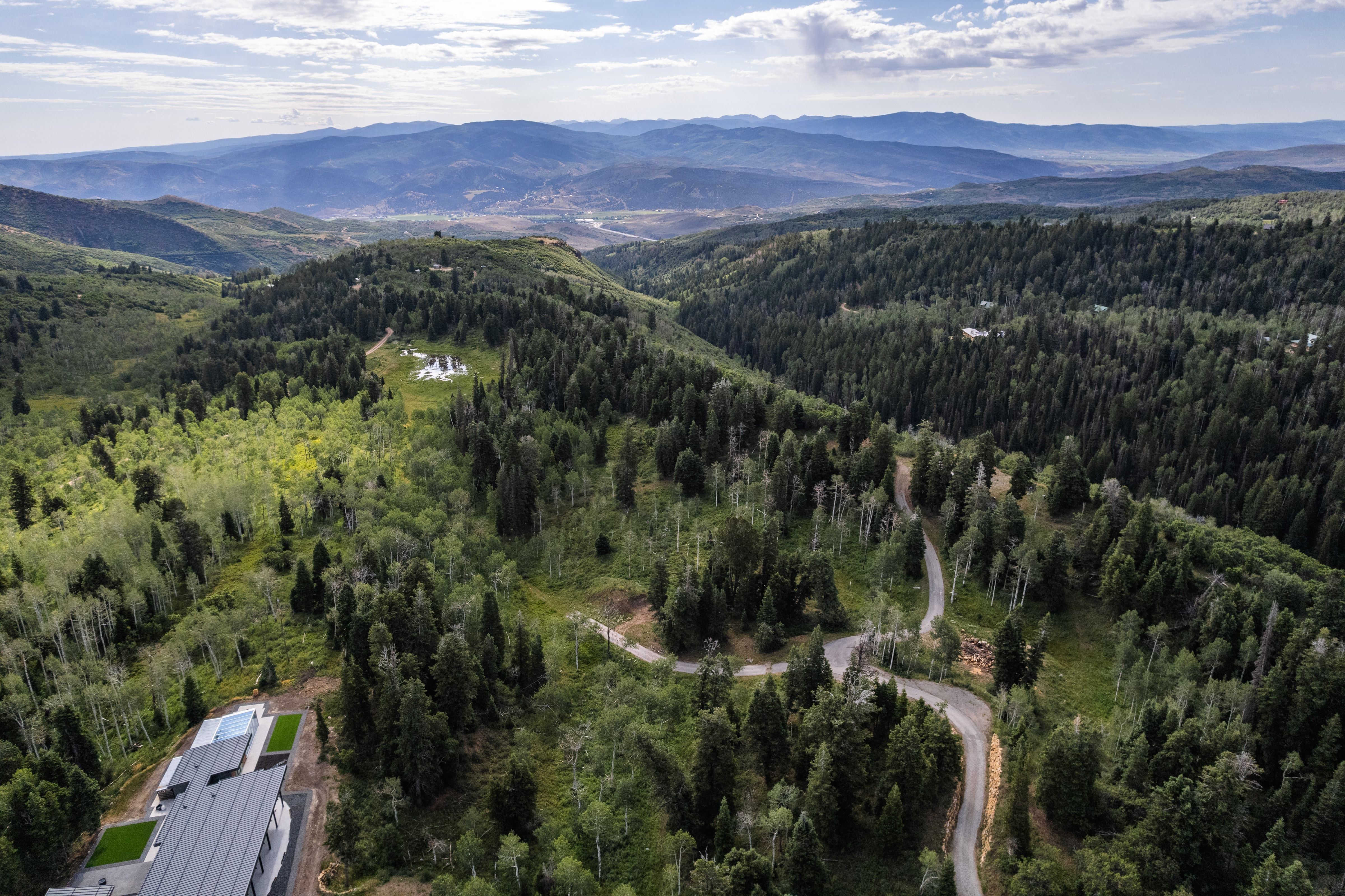 Expansive mountainous landscape with dense evergreen and deciduous trees