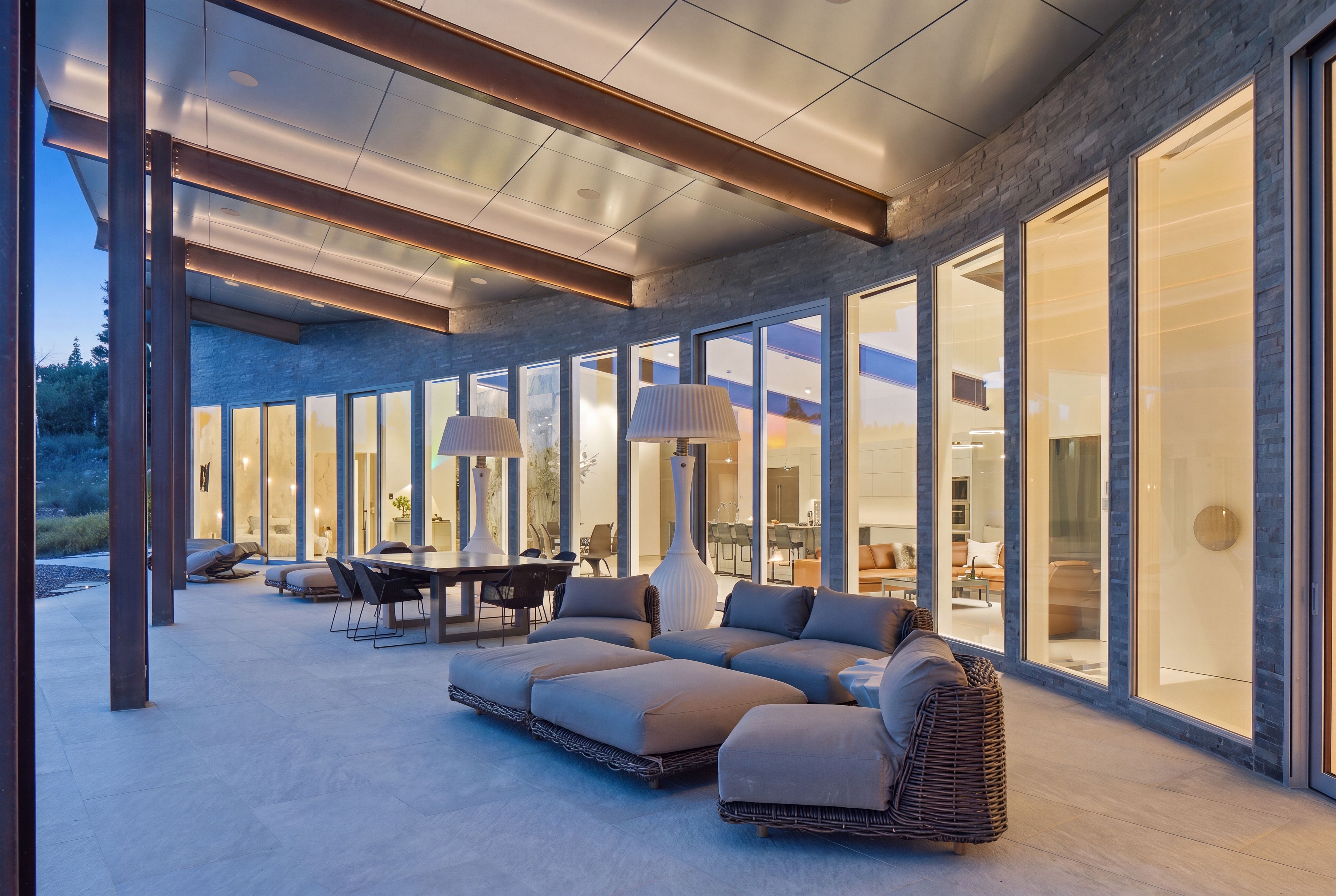 Expansive covered patio featuring a concrete surface and a stone-clad exterior wall