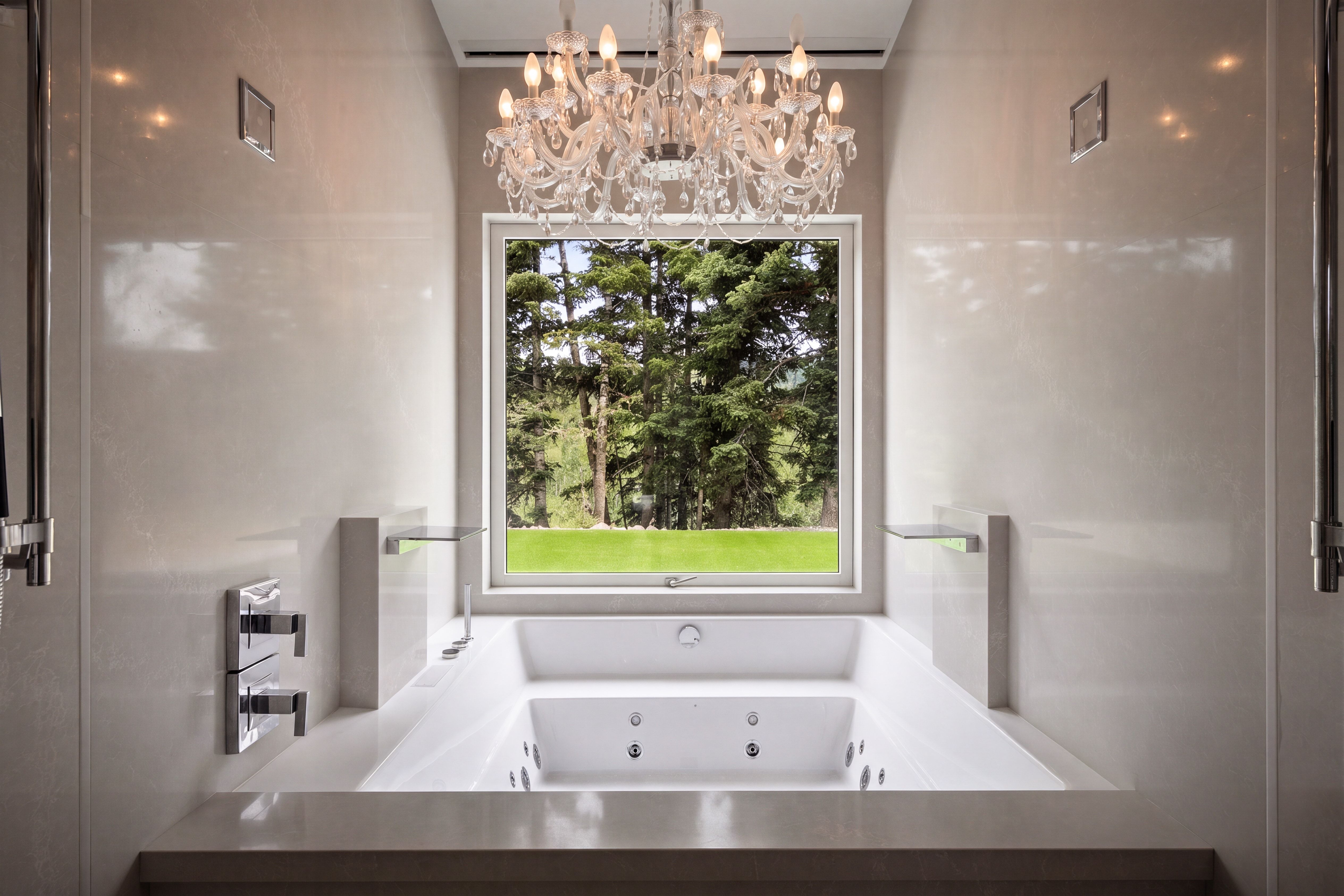 Built-in jetted tub with a window offering a lush green backdrop