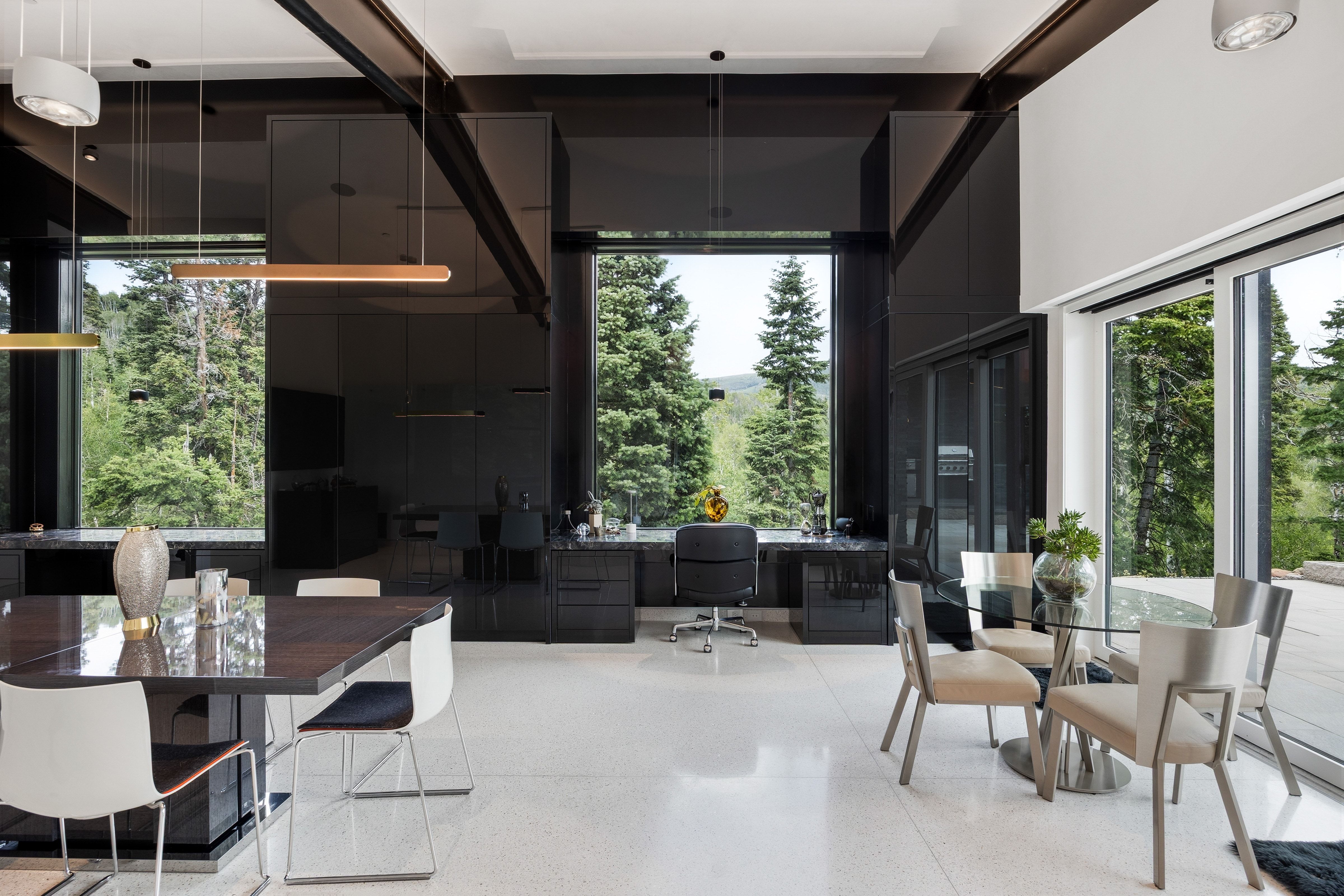 Expansive interior space featuring white flooring, floor-to-ceiling windows, and black built-in cabinetry
