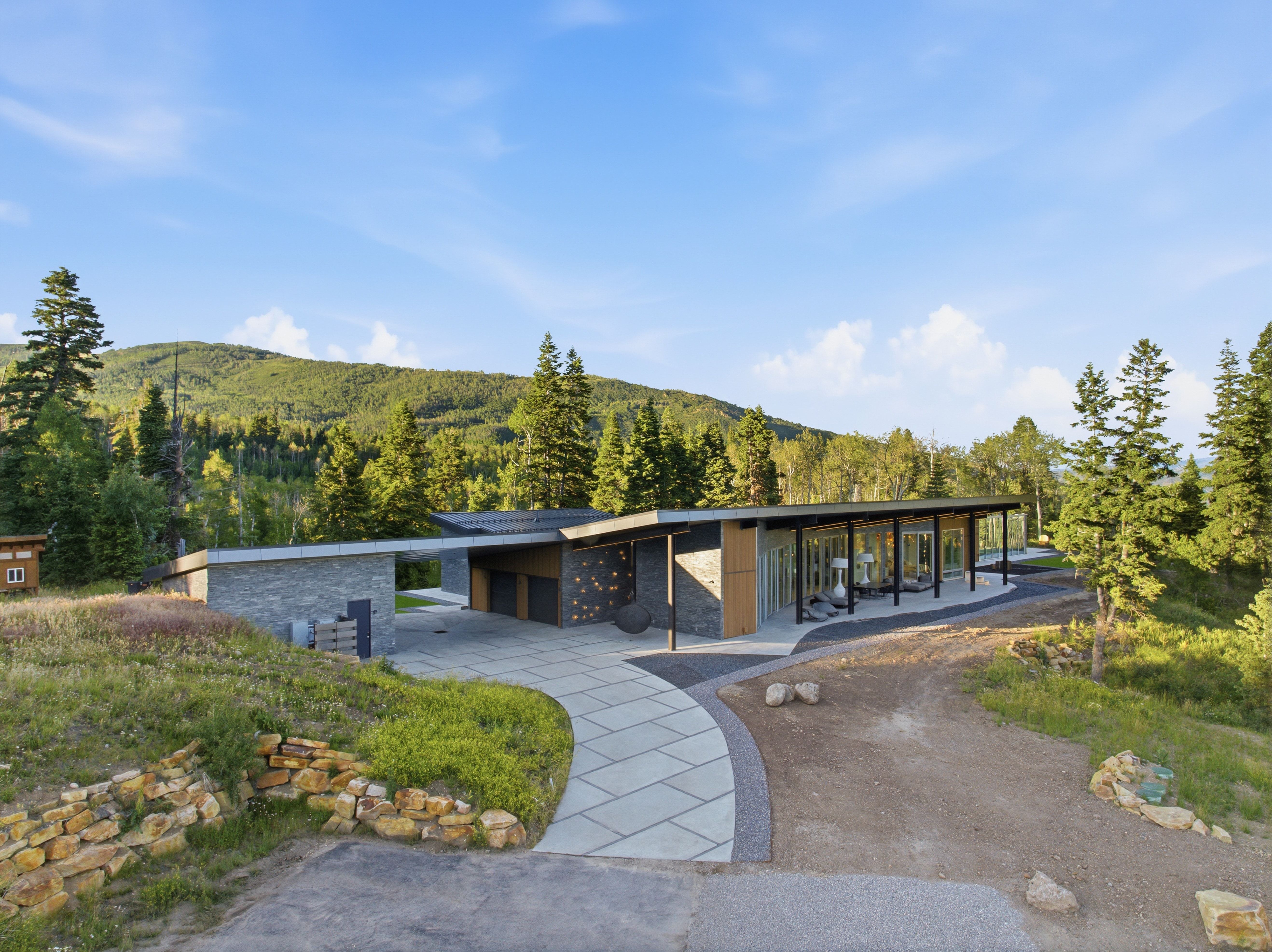 Modern architecture with a flat roofline, stone veneer, and extensive floor-to-ceiling windows