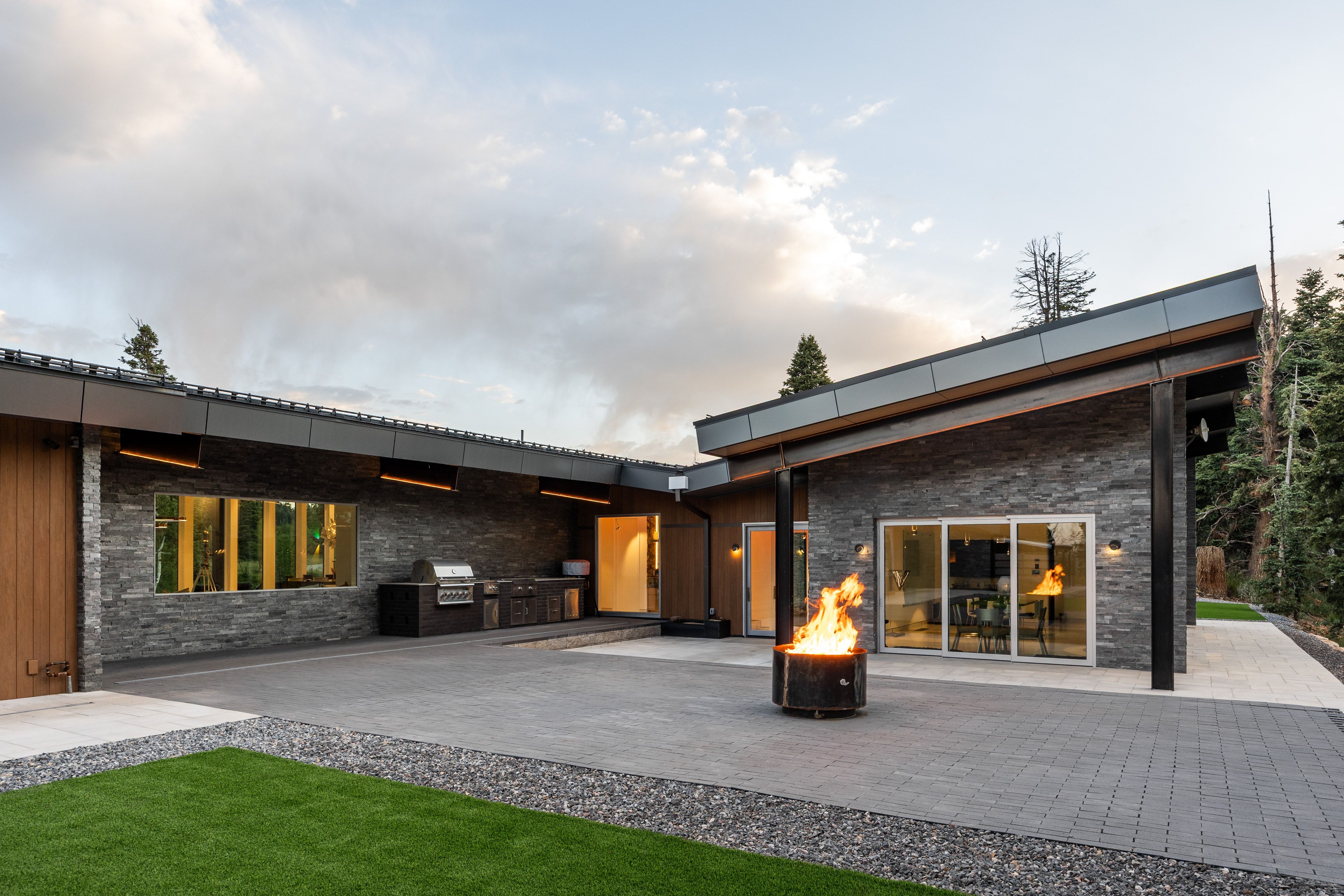 Expansive outdoor patio featuring gray paver flooring and a built-in outdoor kitchen with grill