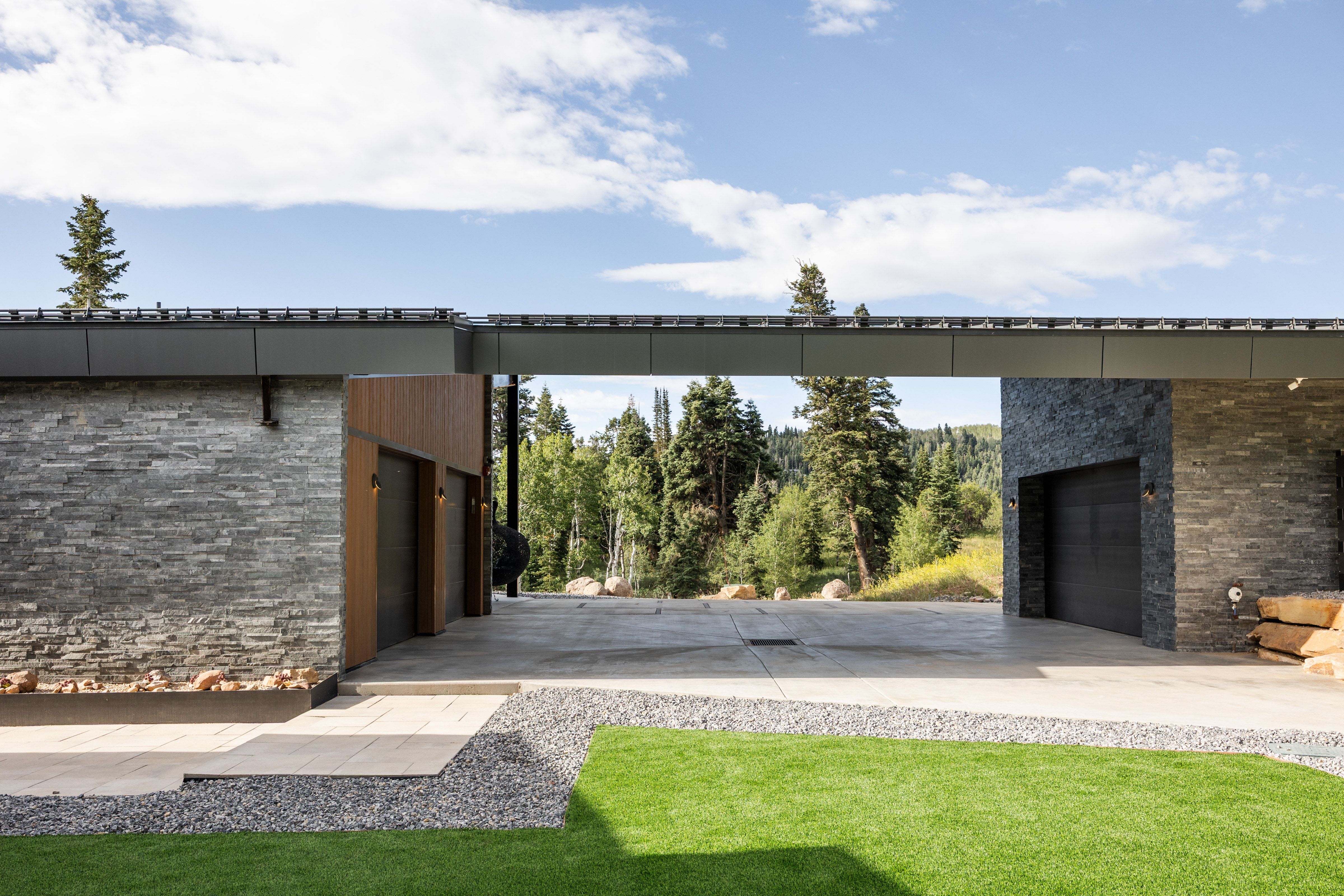 Modern architectural design featuring dark stacked stone and wood-finish paneling