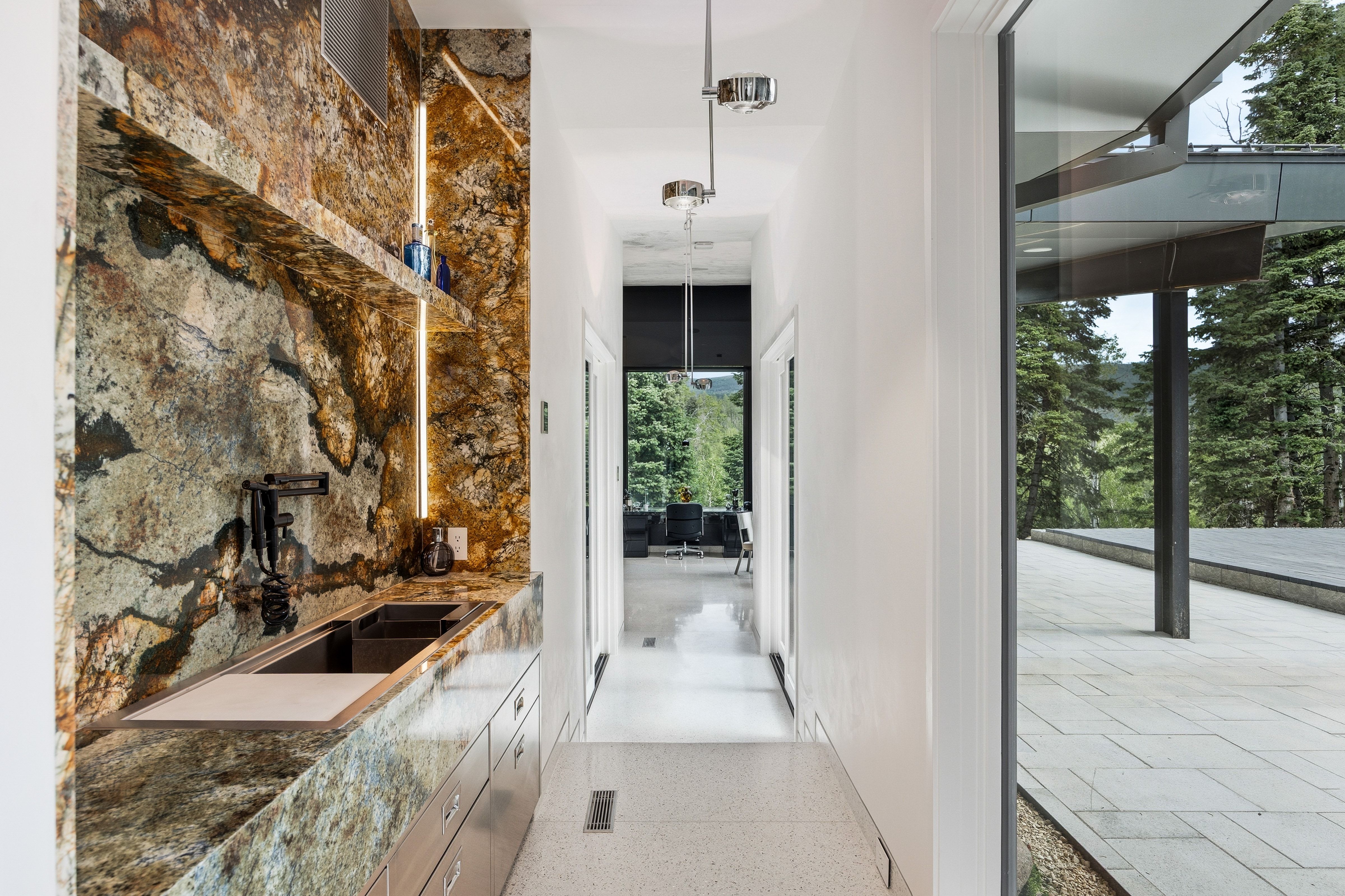 Hallway with a built-in wet bar featuring a stone countertop and backsplash with integrated linear lighting