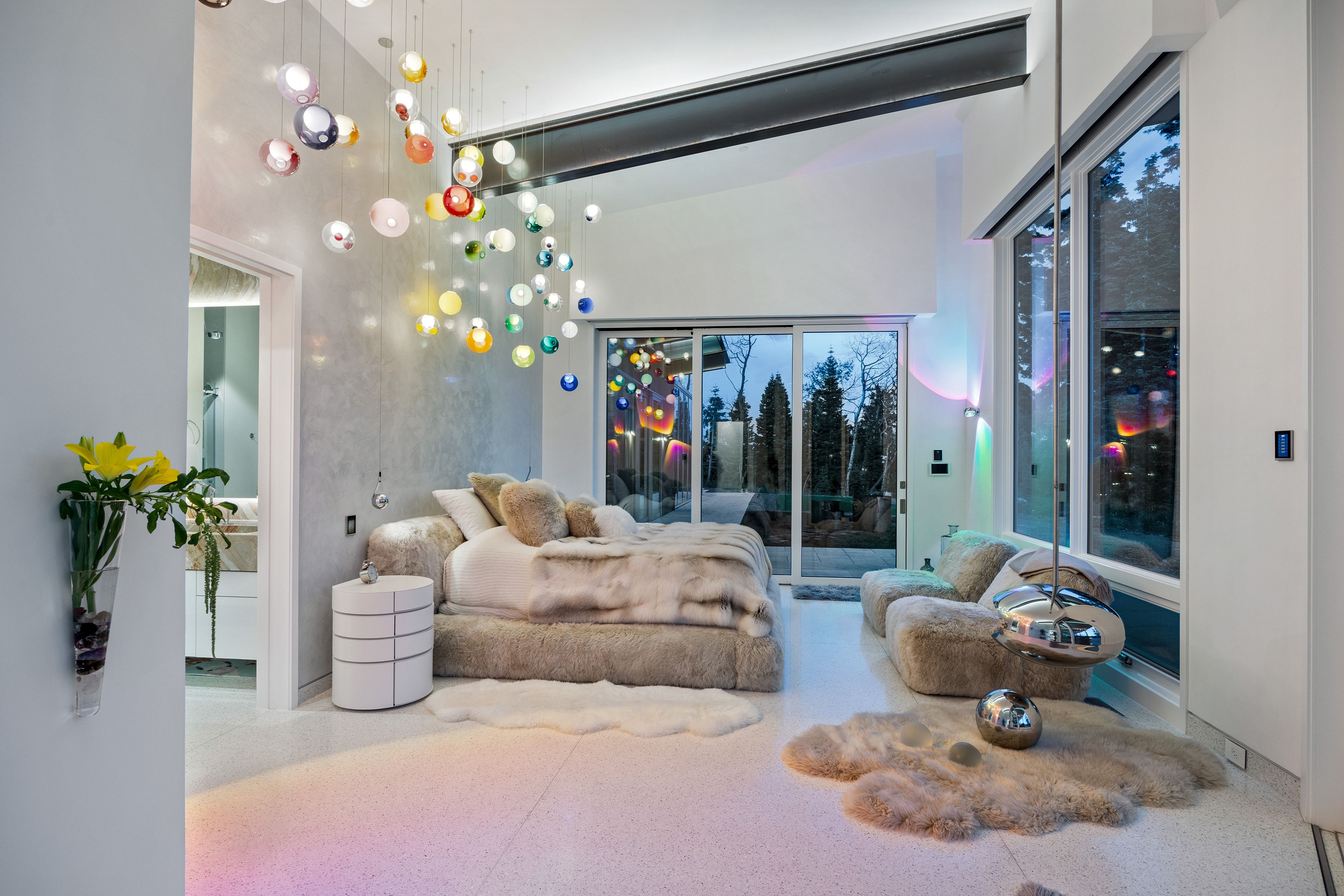Spacious room featuring a vaulted ceiling and an expansive multi-color glass chandelier