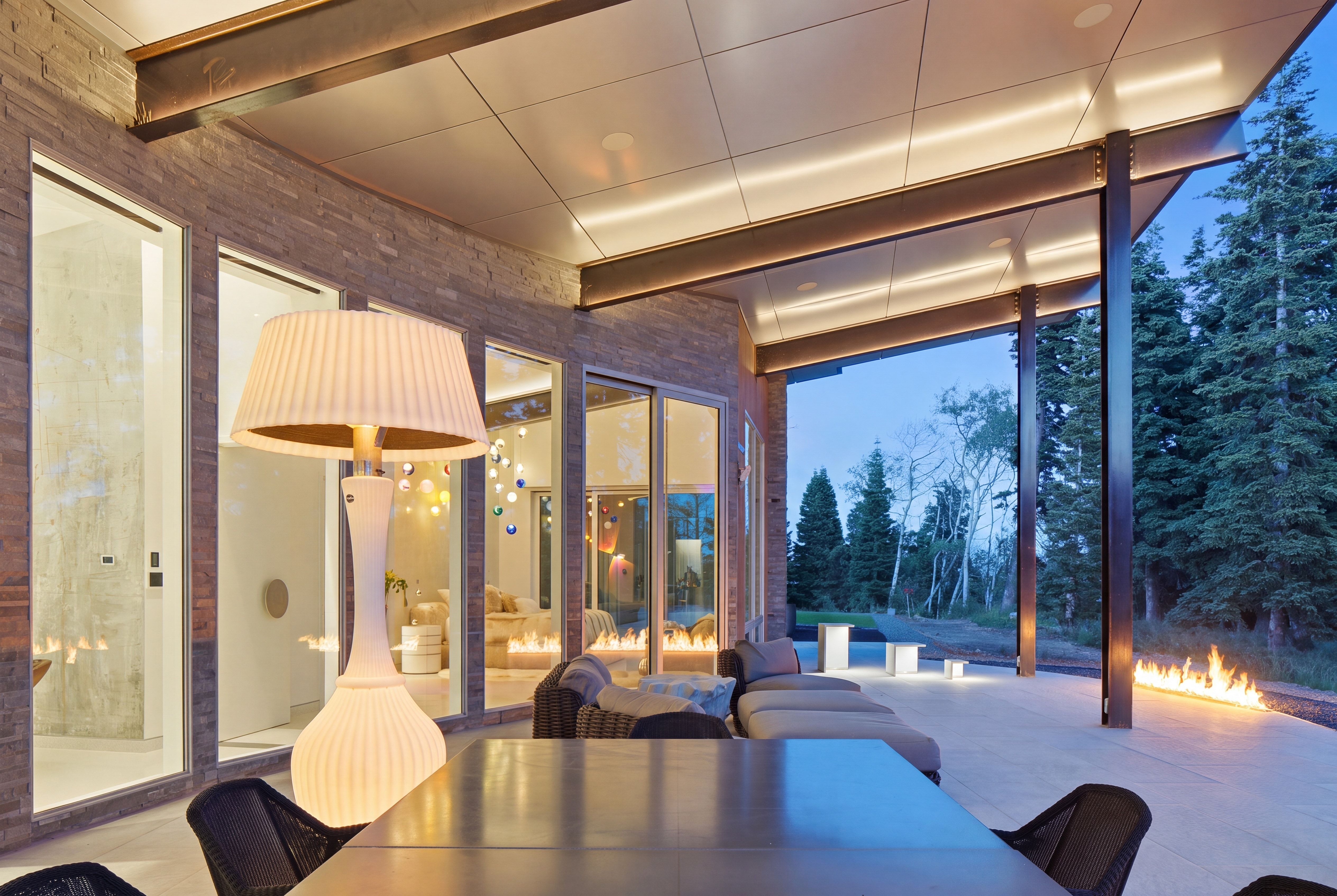 Expansive covered patio featuring a concrete floor, stone-clad exterior walls, and a linear fire pit