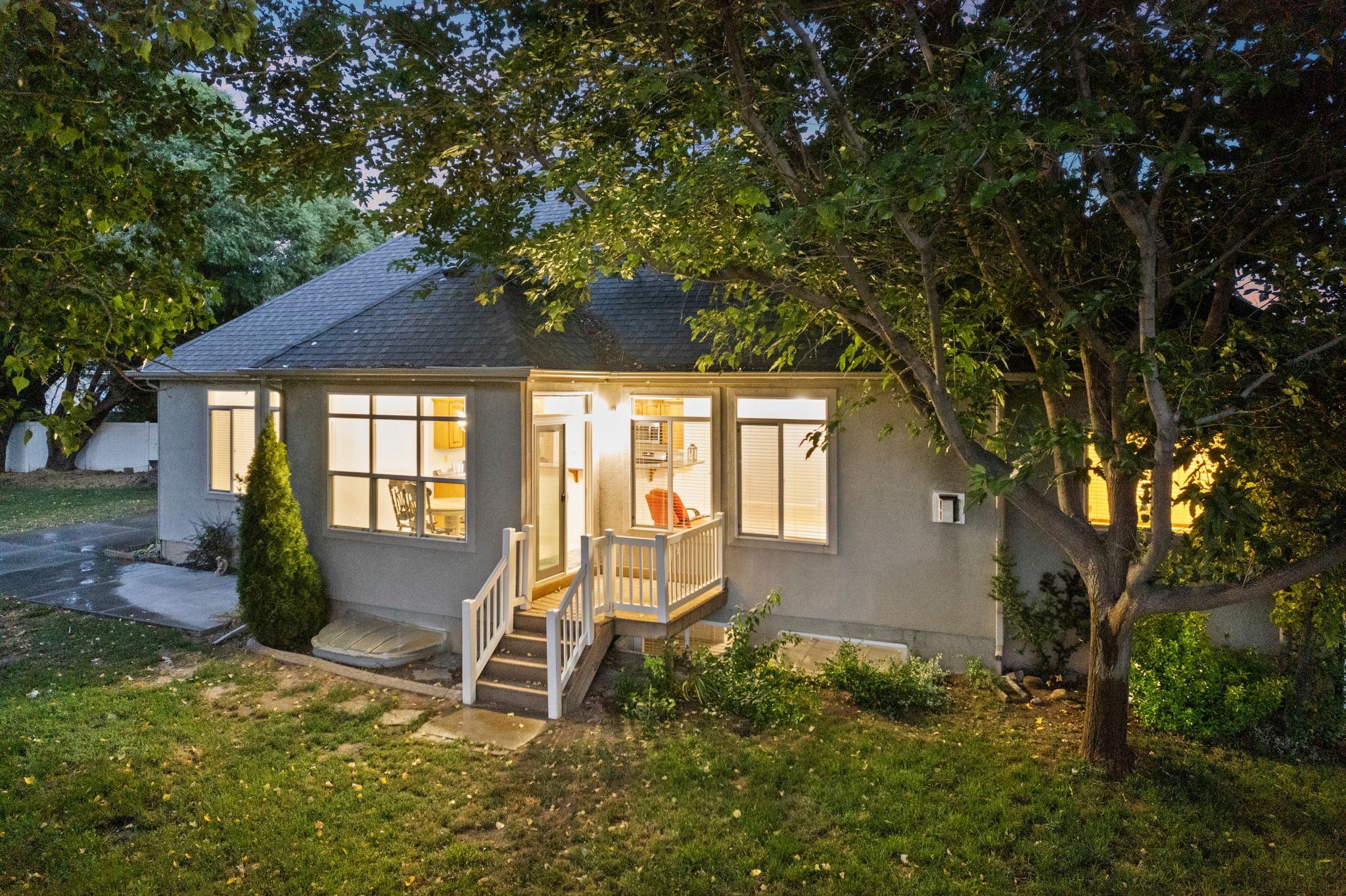 Single-story residence featuring a gray exterior, dark shingle roof, and multiple windows