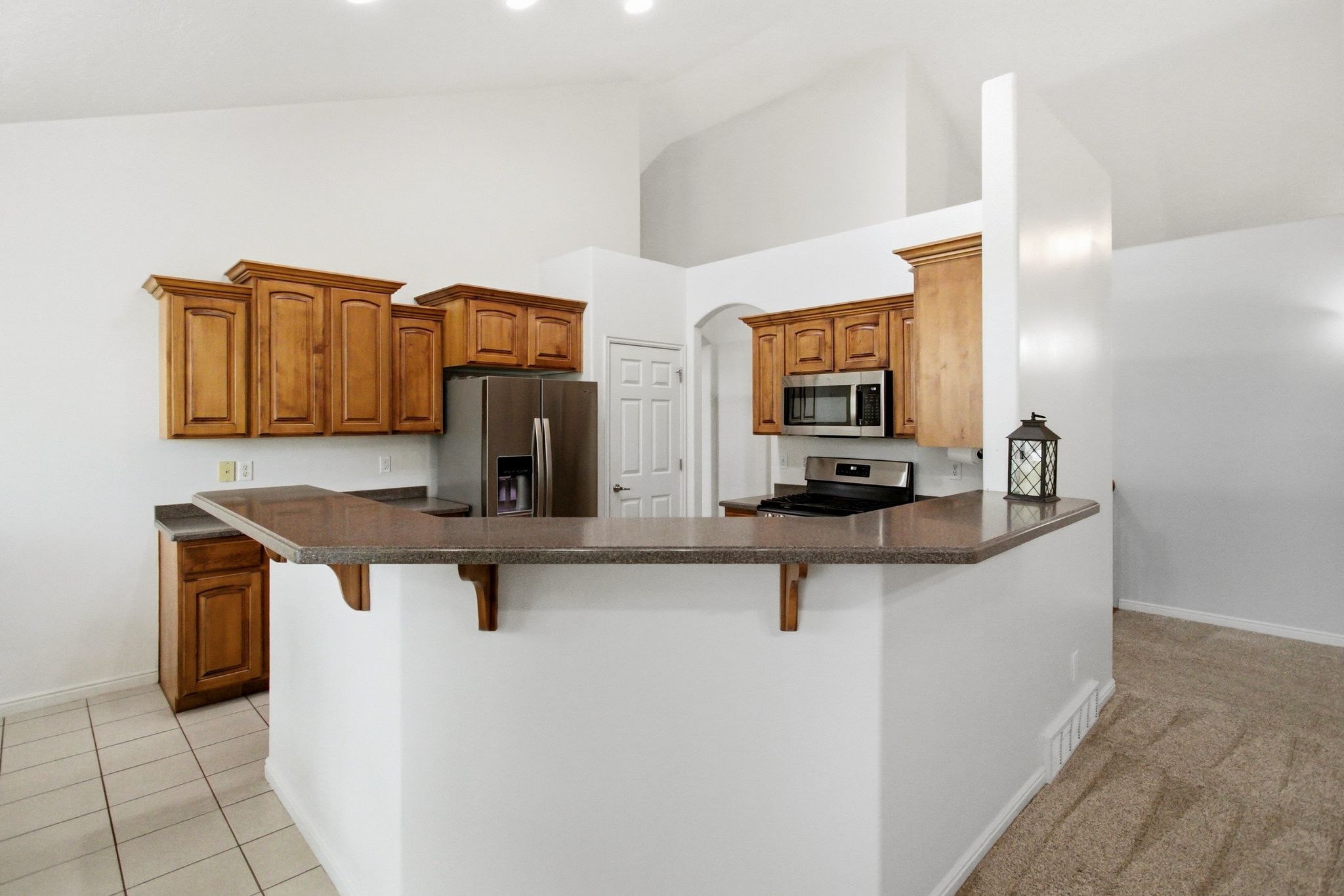 Kitchen featuring wood cabinetry, stainless steel appliances, and a breakfast bar