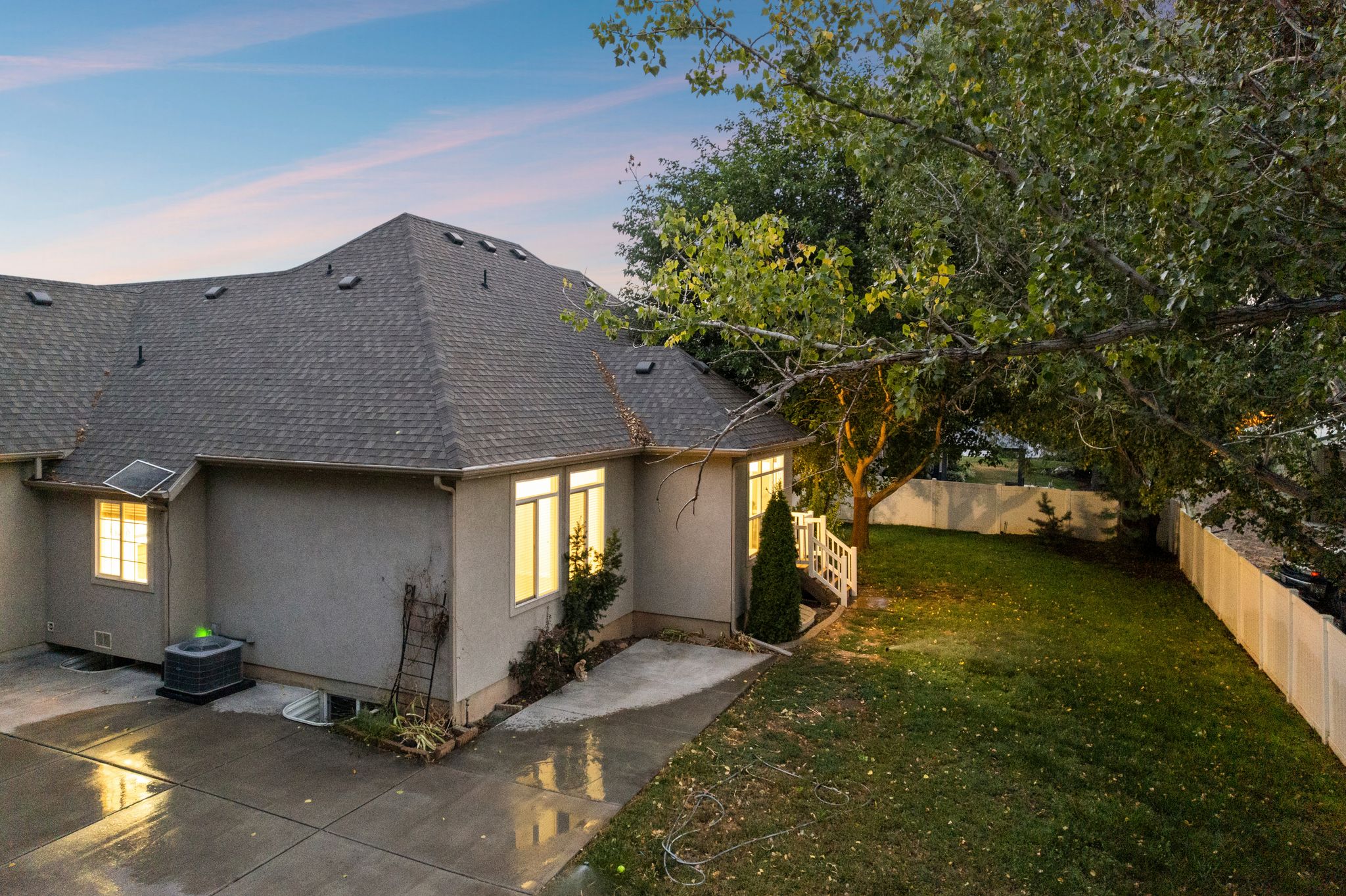 Exterior with a dark shingle roof and light stucco siding