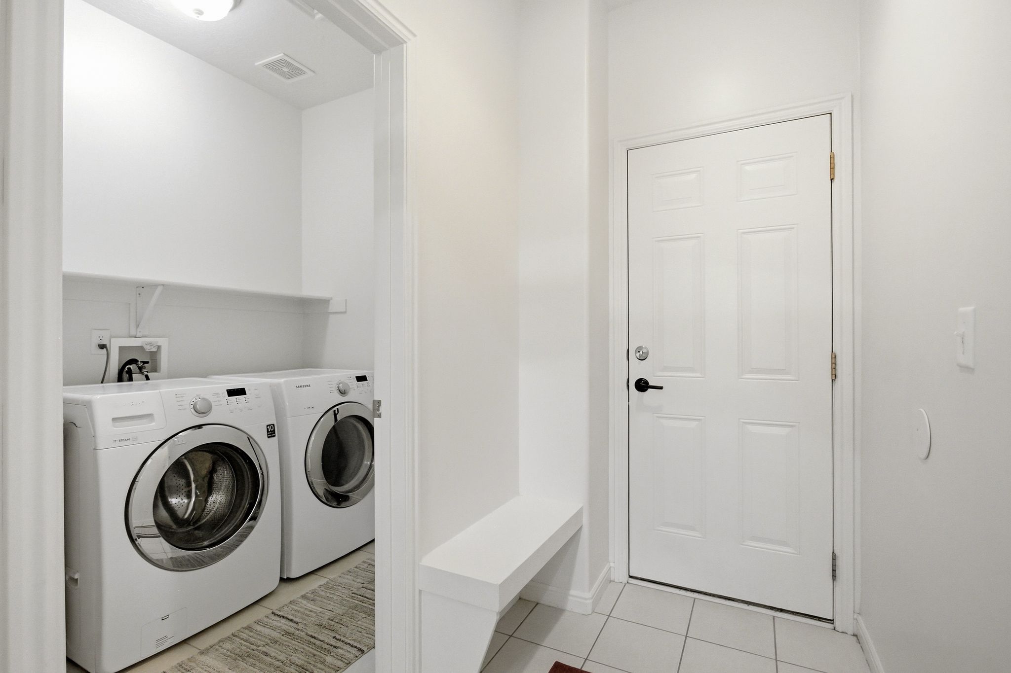 Dedicated laundry area featuring a built-in shelf and overhead lighting
