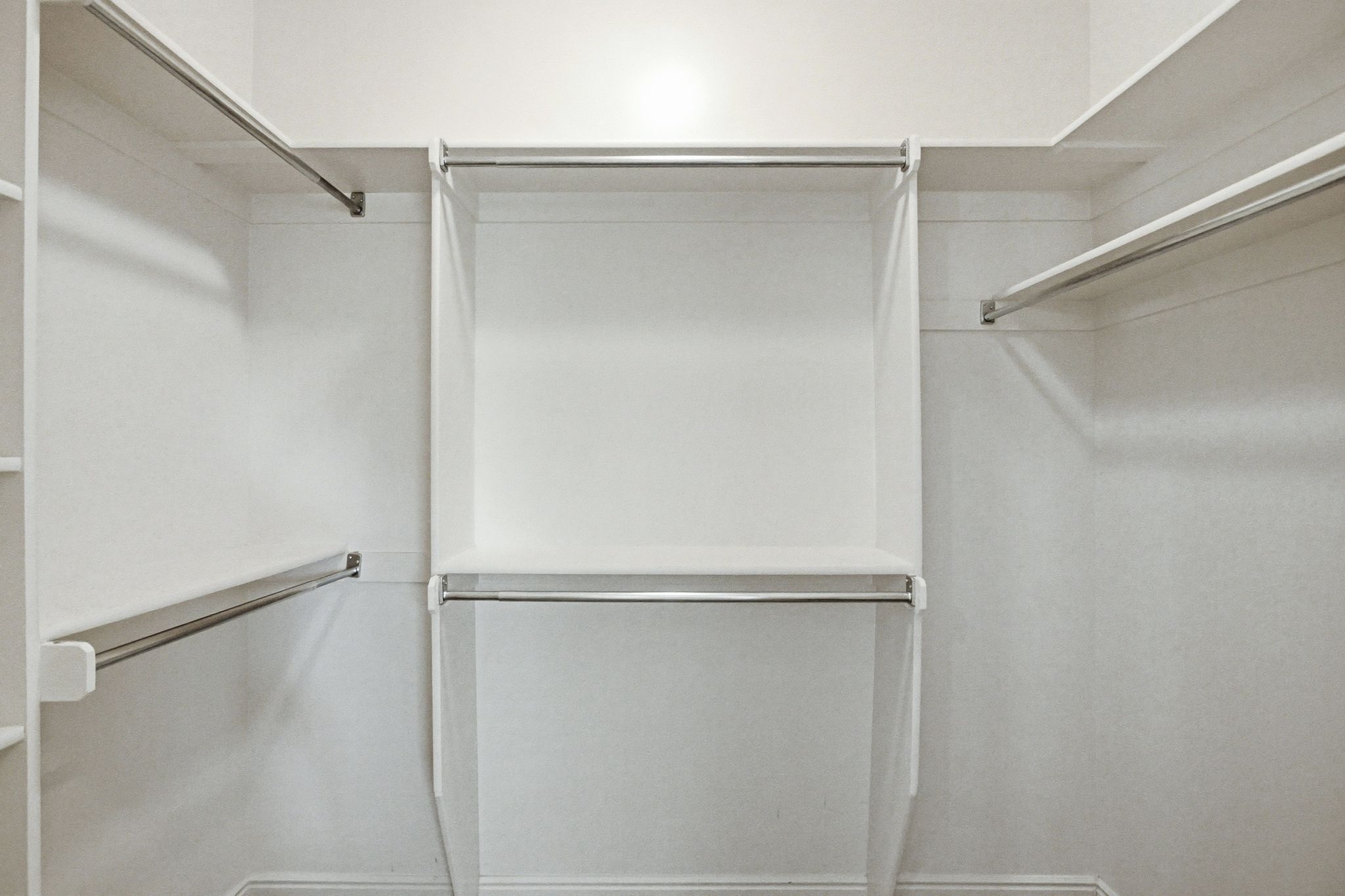 White closet system featuring multiple shelves and hanging rods