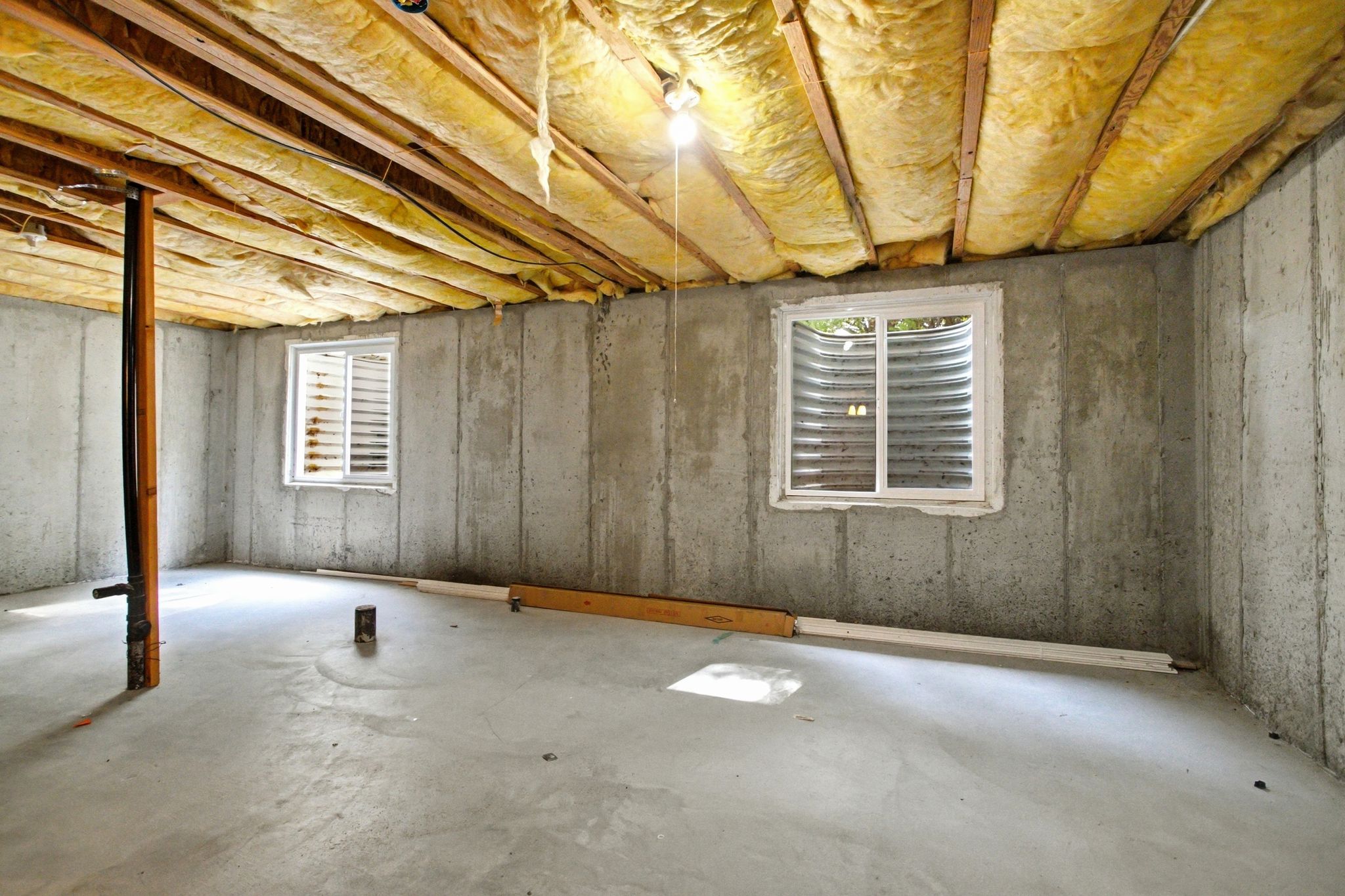 Expansive unfinished basement featuring concrete walls and flooring