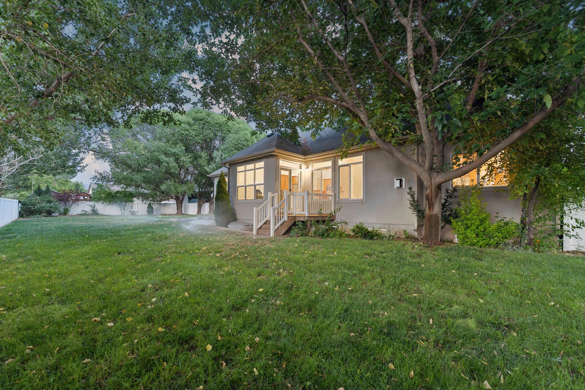Spacious backyard with mature trees and a manicured lawn
