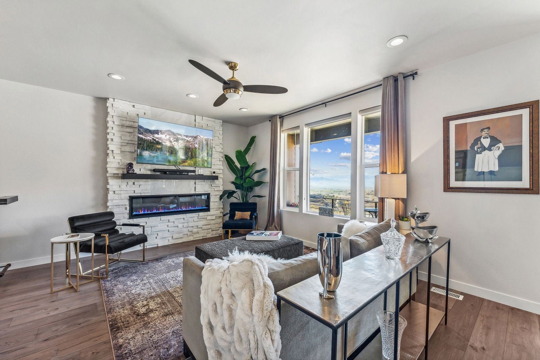 Living area featuring a floor-to-ceiling stacked stone fireplace with an integrated electric fireplace