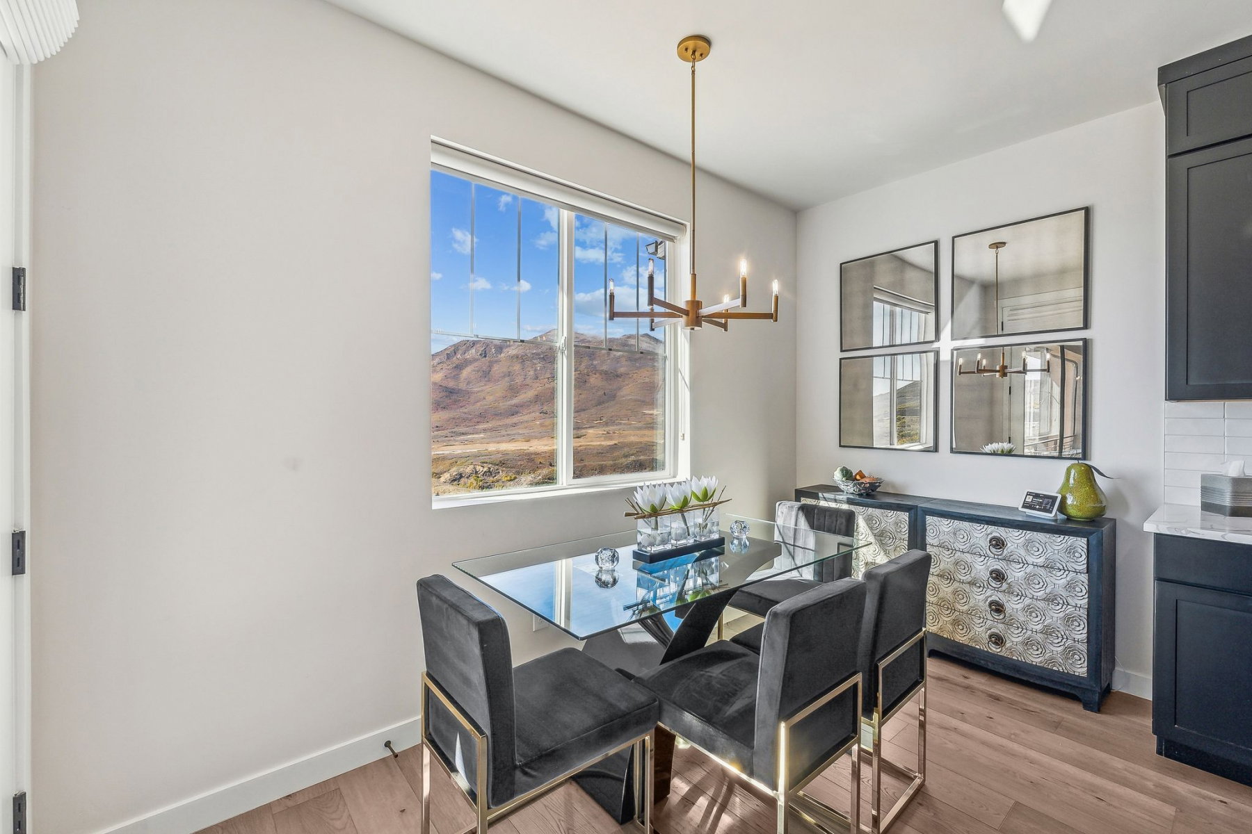 Dining area featuring a large window with mountain scenery, a brass chandelier, and wood-finish flooring