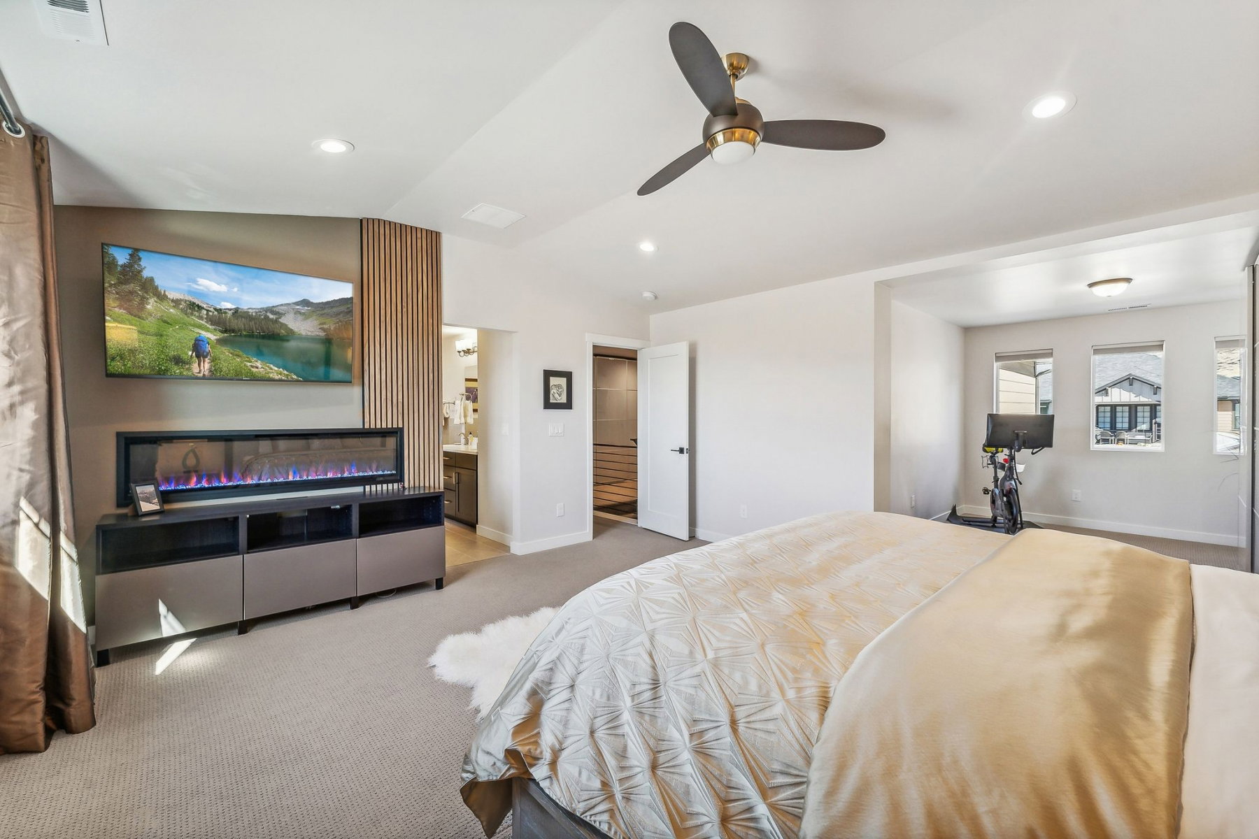 Spacious bedroom featuring vaulted ceilings, recessed lighting, a modern ceiling fan, and carpeted flooring