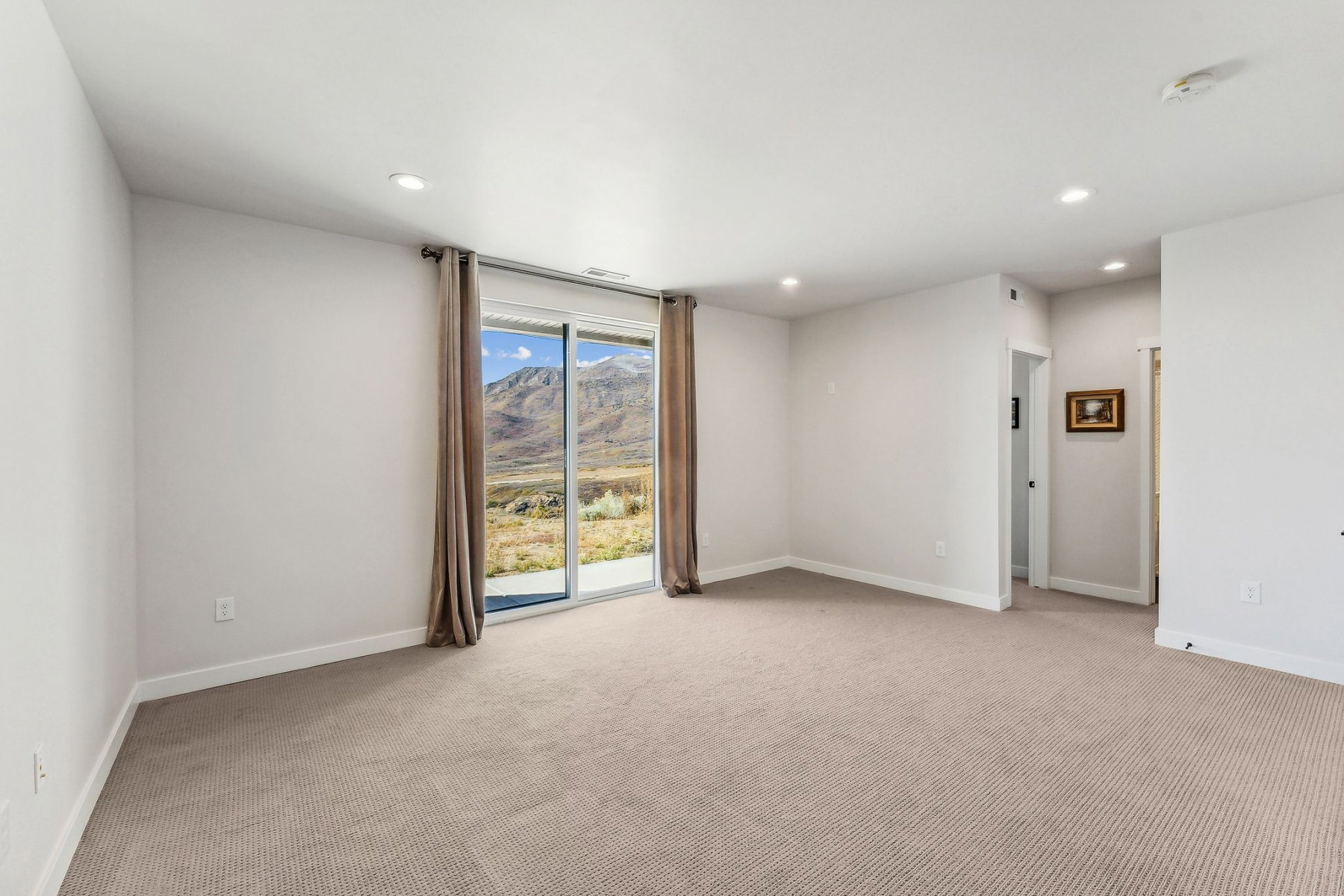 Carpeted room with recessed lighting and a sliding glass door