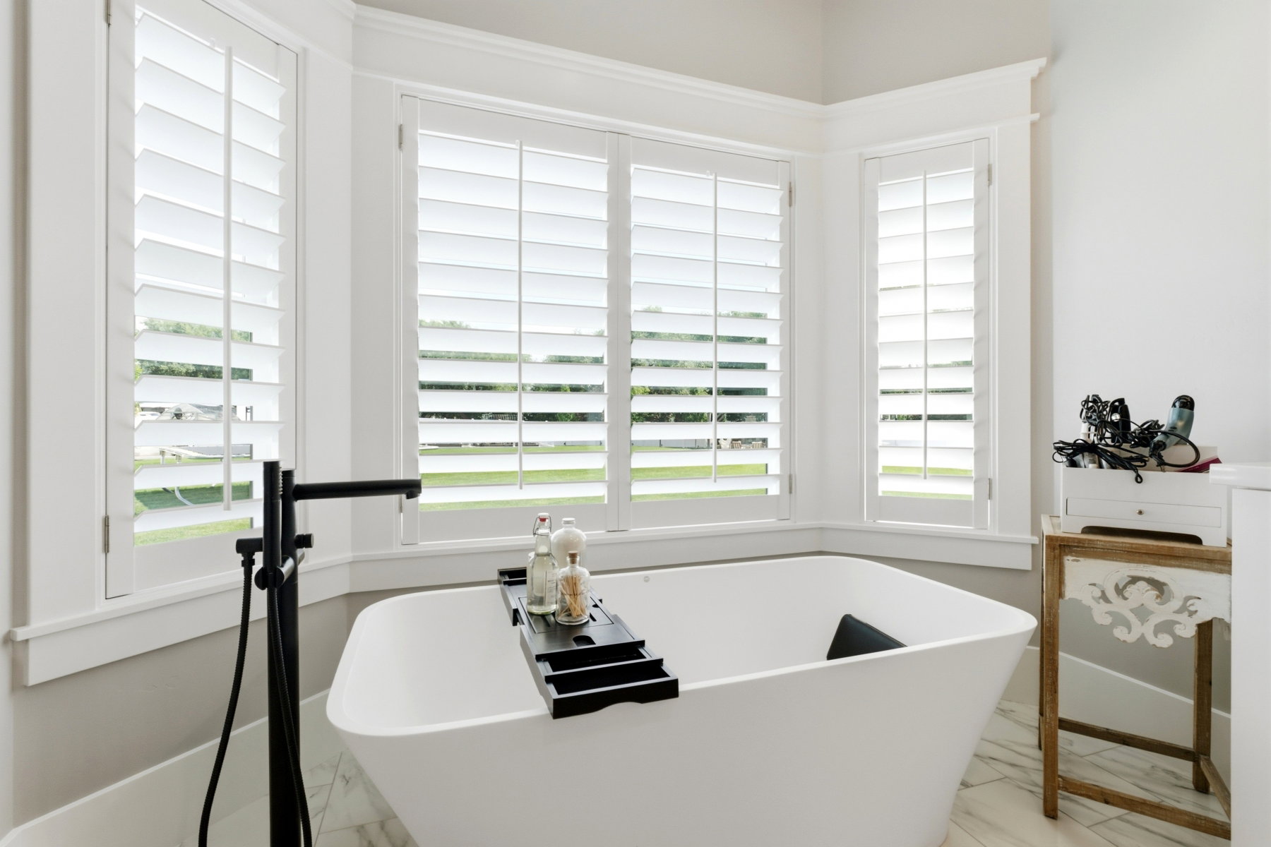 Freestanding soaking tub with a floor-mounted matte black faucet