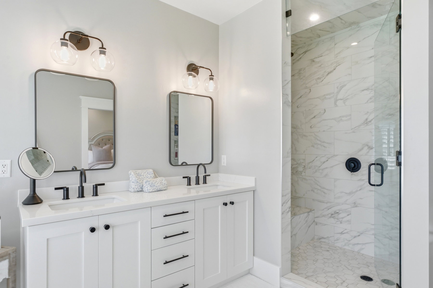 Dual vanity with white cabinetry, matte black hardware, and rectangular undermount sinks