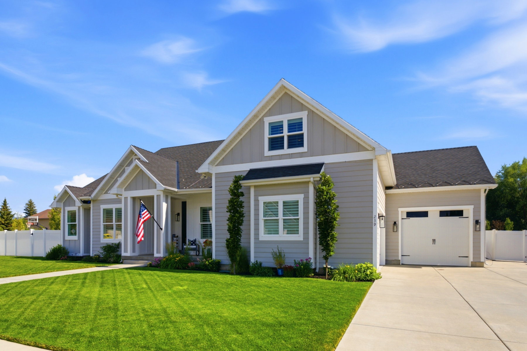 Single-level residence featuring light gray siding, white trim, and a dark shingle roof