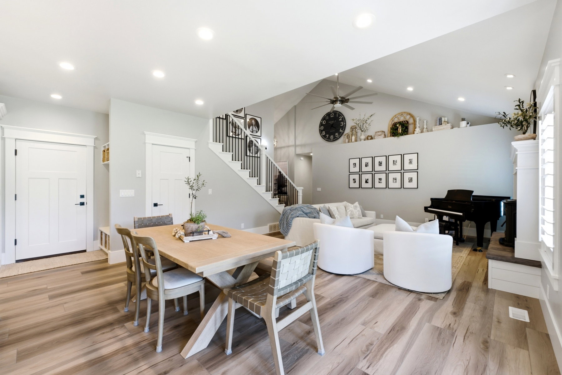 Expansive open-concept living area featuring high vaulted ceilings, recessed lighting, and wood-finish flooring throughout