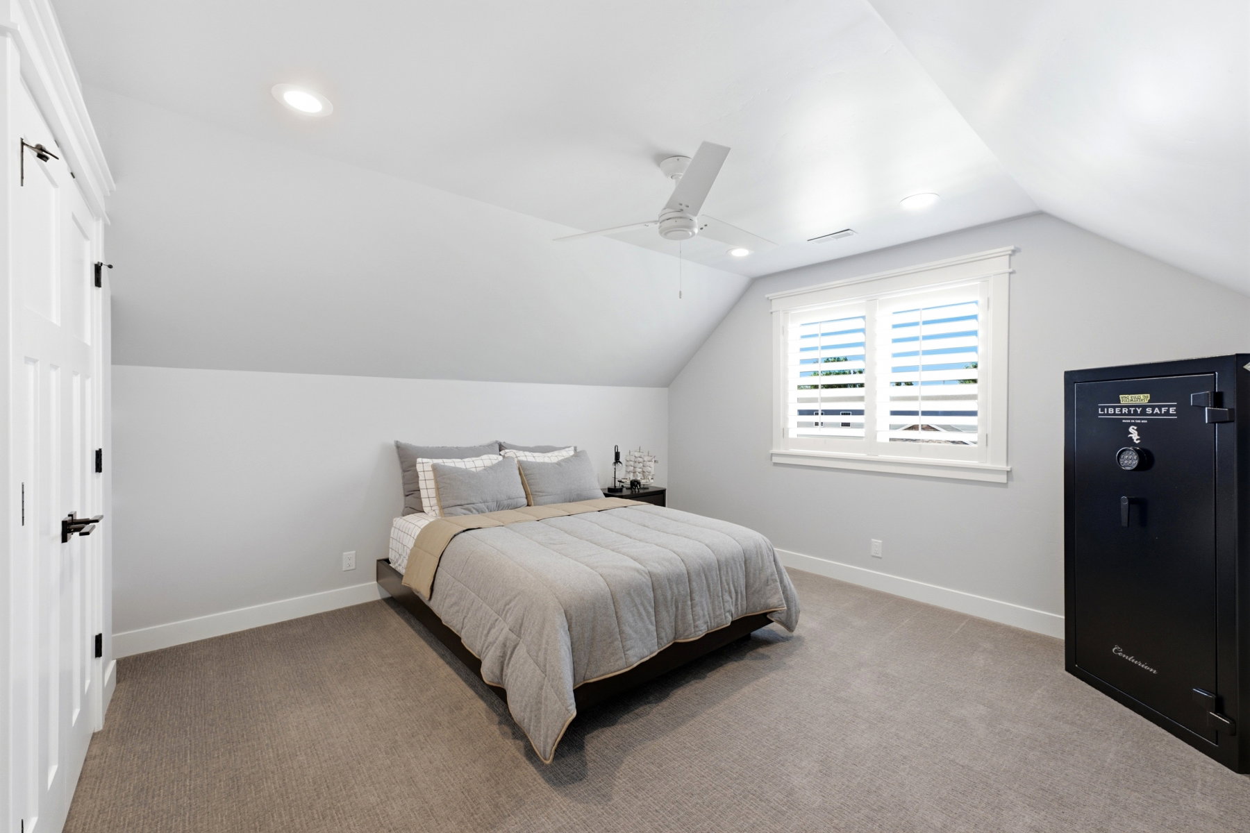 Carpeted sleeping area featuring an angled ceiling, recessed lighting, and a ceiling fan