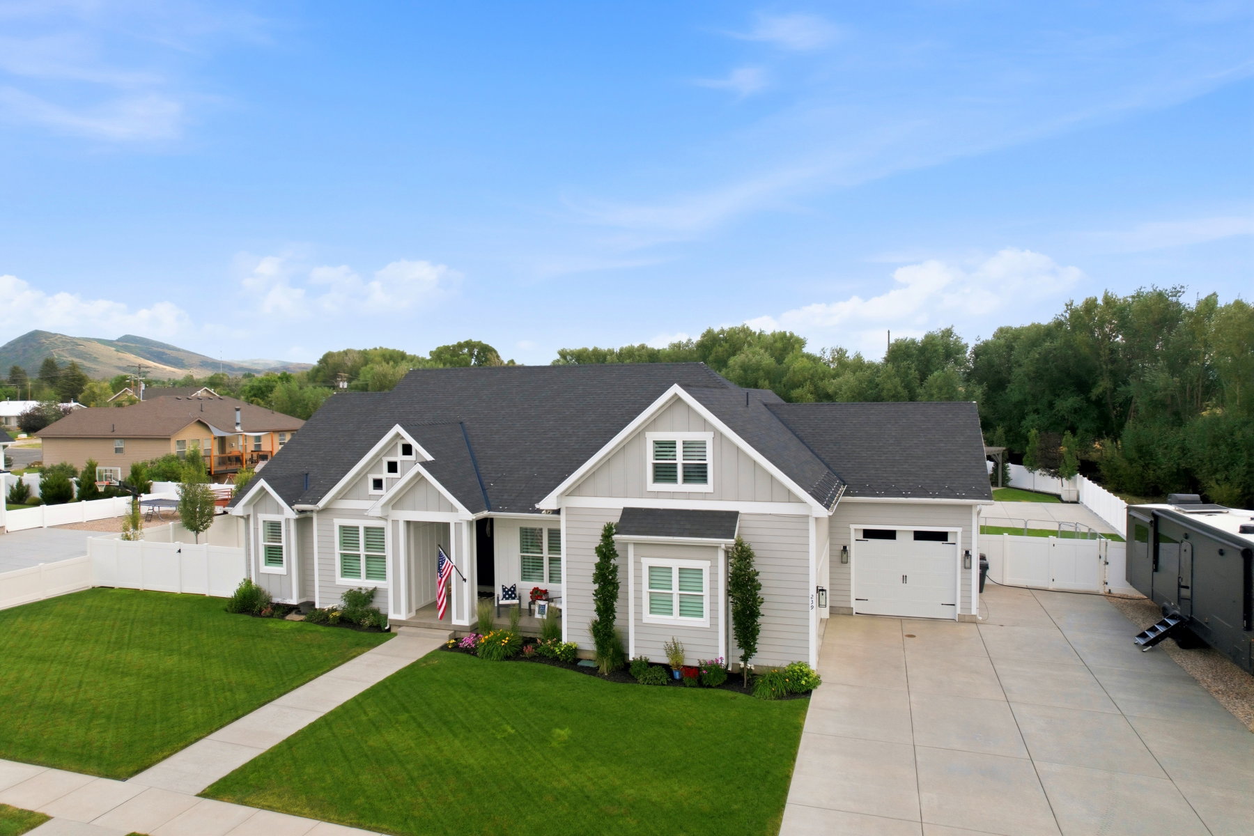 Single-story residence featuring light gray siding and dark roof shingles