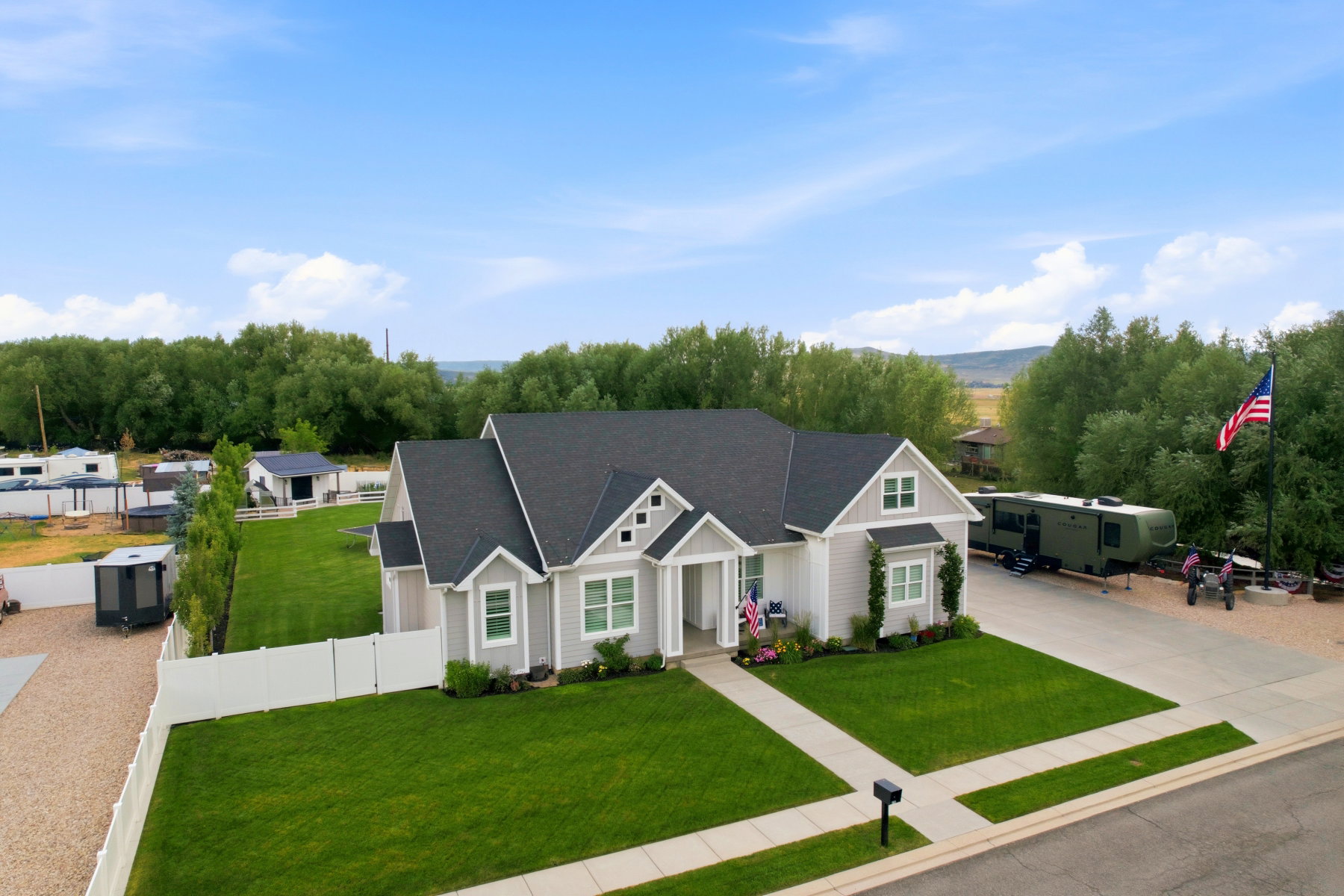 Contemporary home featuring light grey siding, white trim, and a dark shingle roof