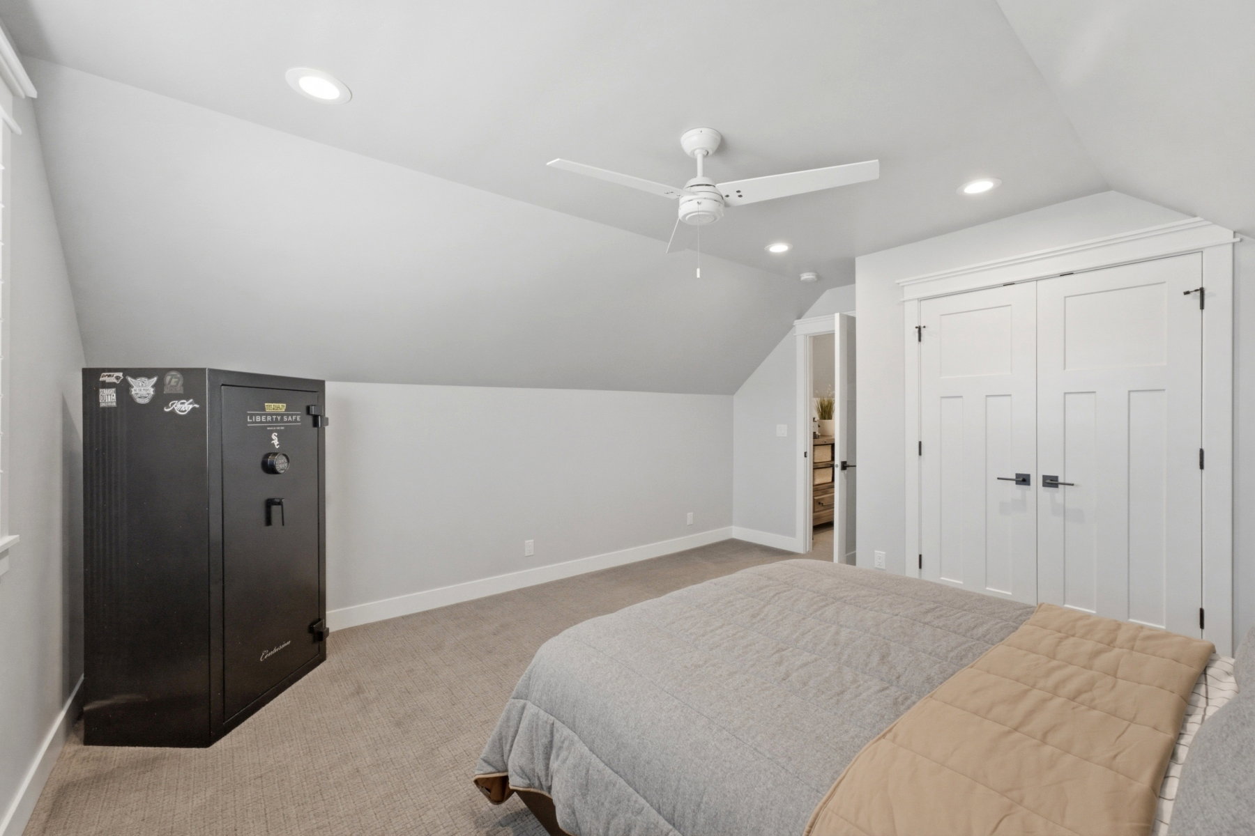 Carpeted room with sloped ceilings, recessed lighting, a ceiling fan, and white paneled bifold closet doors with dark hardware
