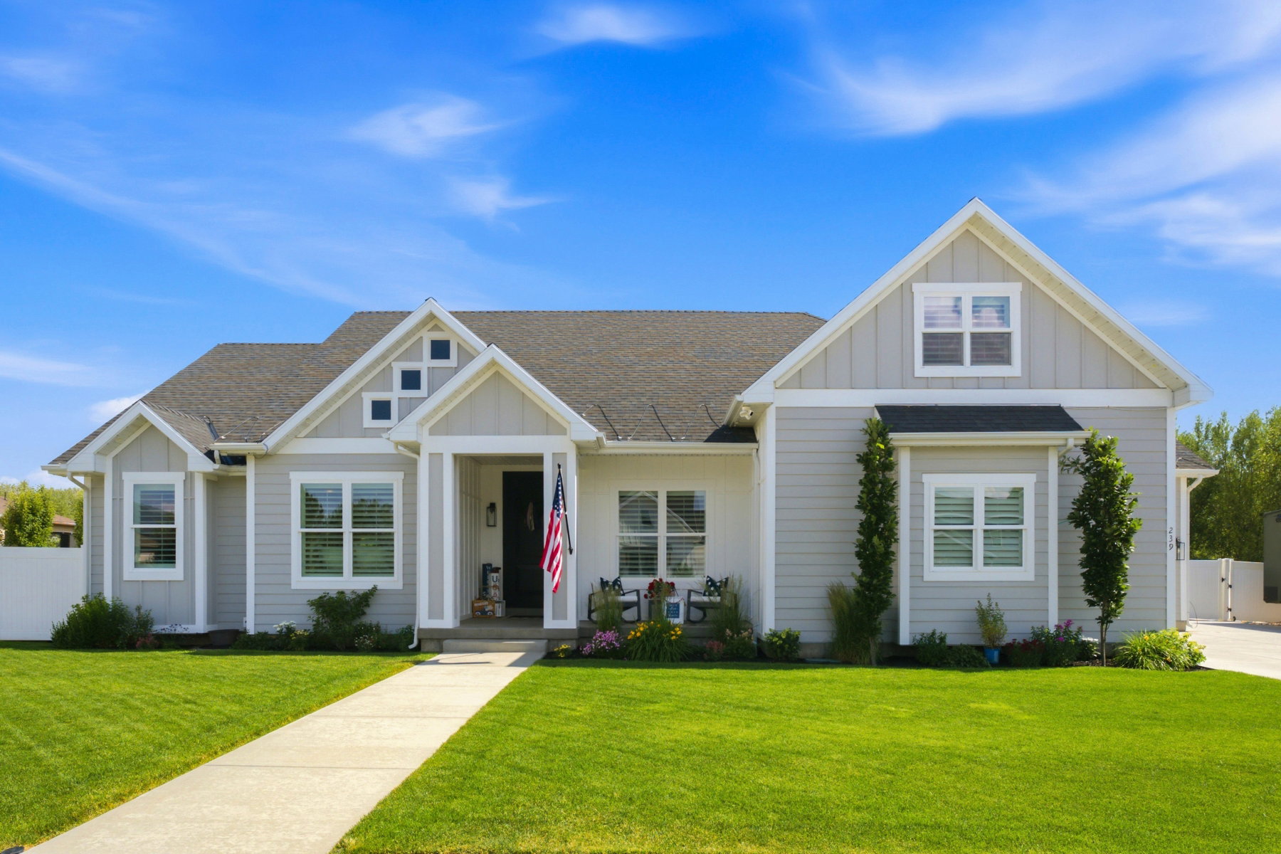 Contemporary ranch-style residence featuring light gray siding and white trim