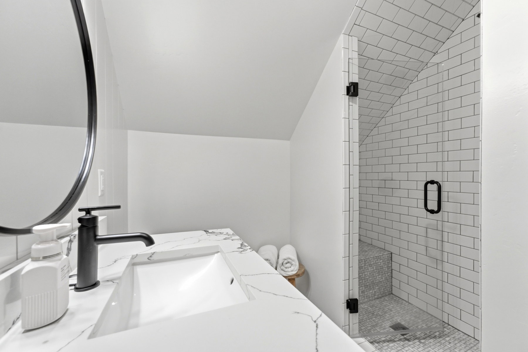 White subway tile shower with a built-in bench