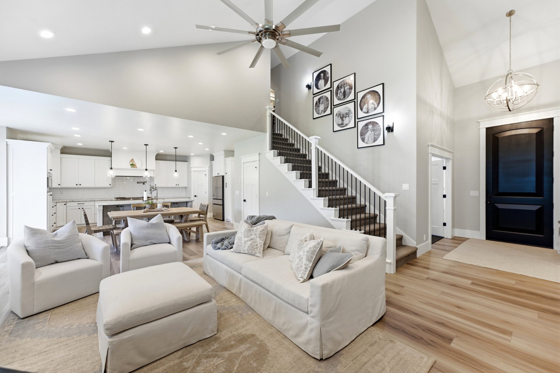 Expansive living area featuring vaulted ceilings, wood-finish flooring, and a contemporary ceiling fan