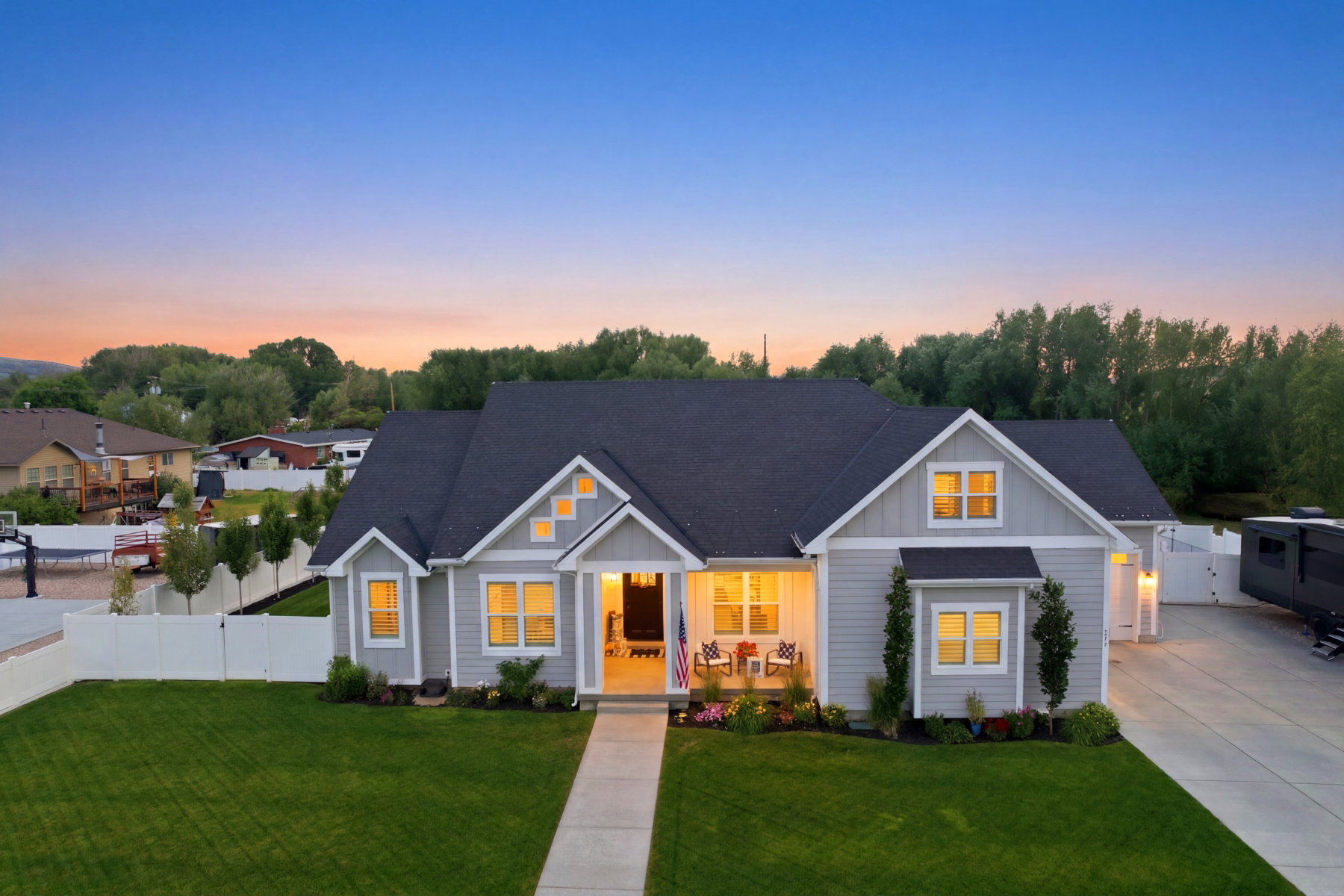 Contemporary ranch-style exterior featuring light gray siding, a dark shingle roof, and white trim