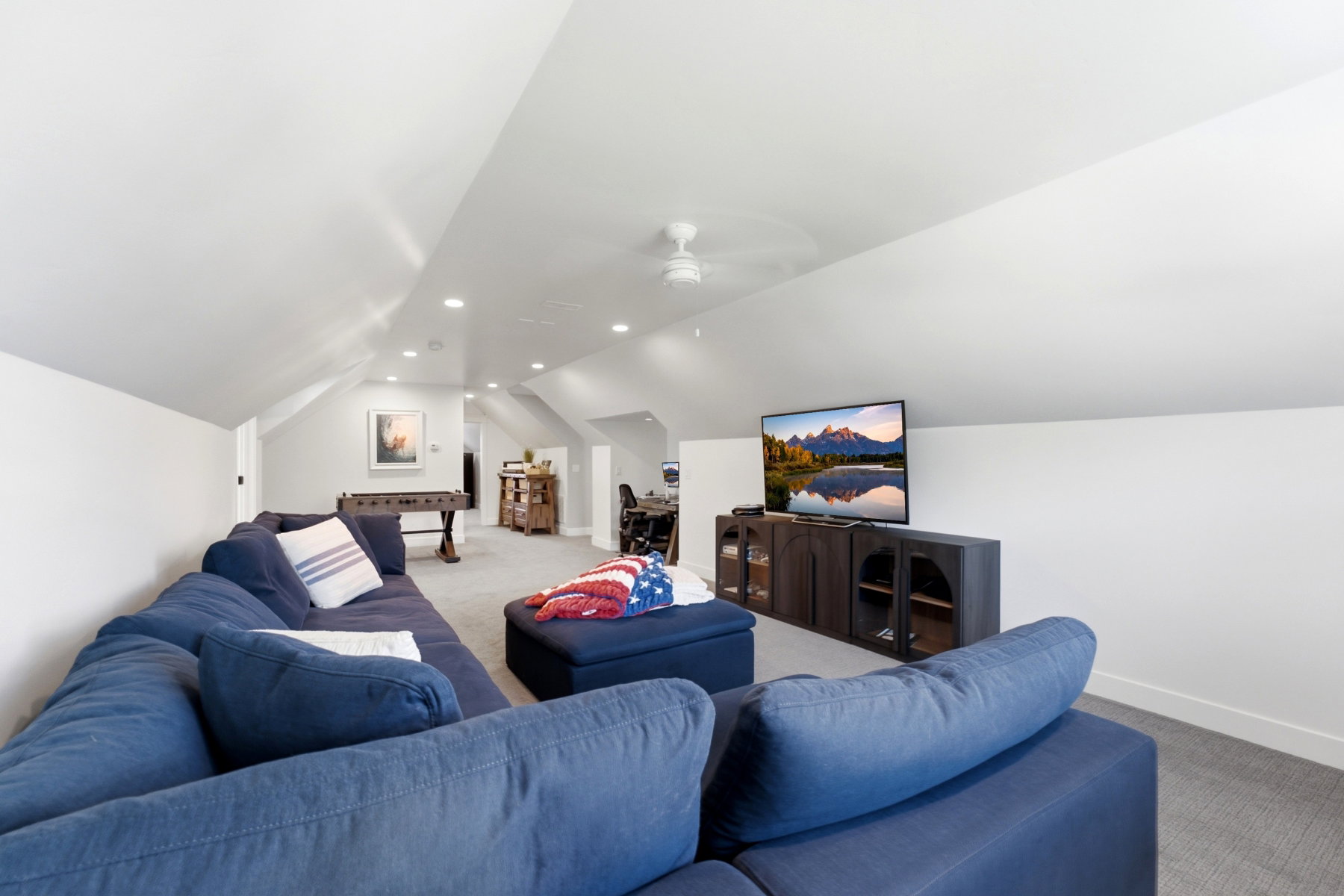 Spacious bonus room featuring vaulted ceilings, recessed lighting, carpet flooring, a ceiling fan, and a built-in media console