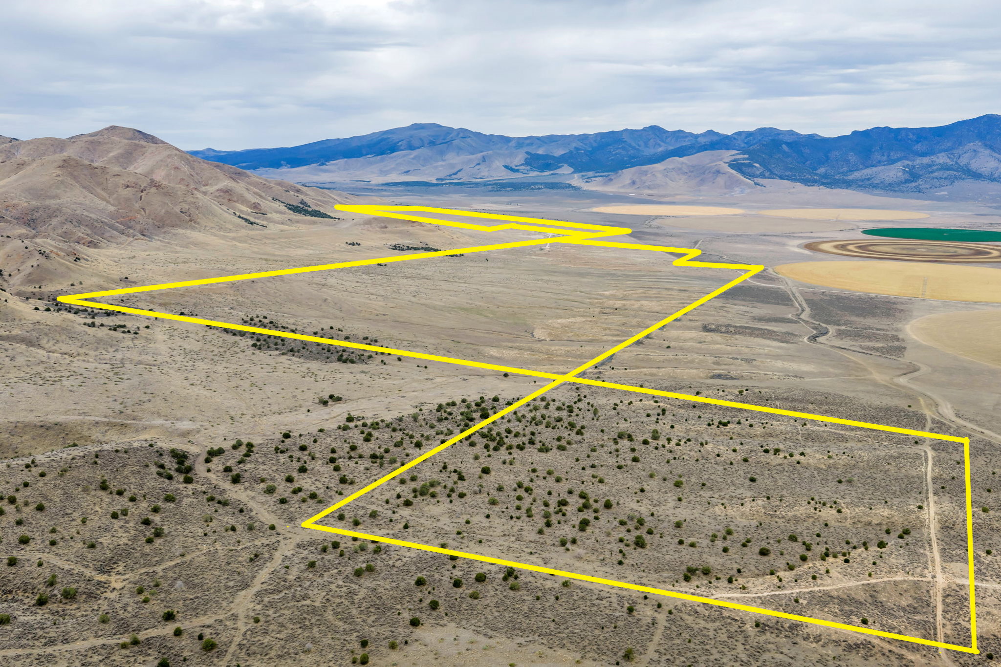 Expansive land parcel outlined in yellow, featuring varied topography including arid plains and a scrubland area