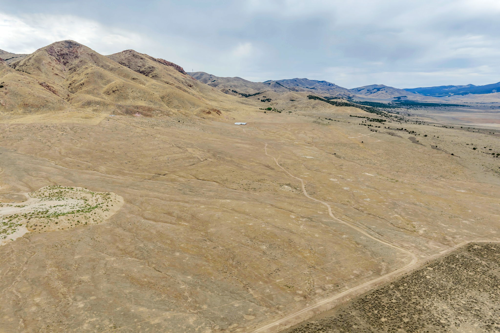 Expansive natural landscape featuring rolling hills and distant mountains