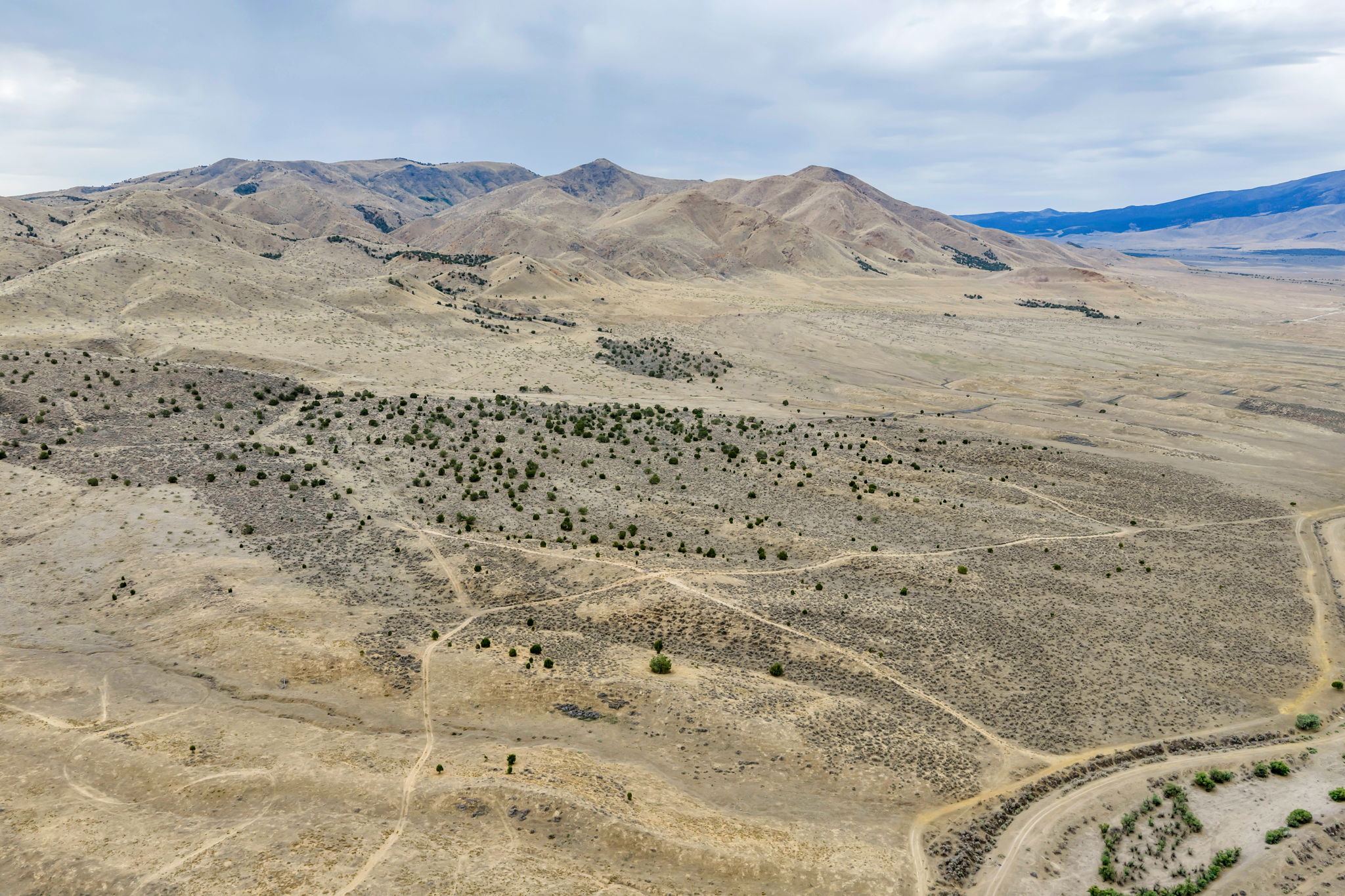 Expansive undeveloped terrain featuring rolling hills and distant mountains