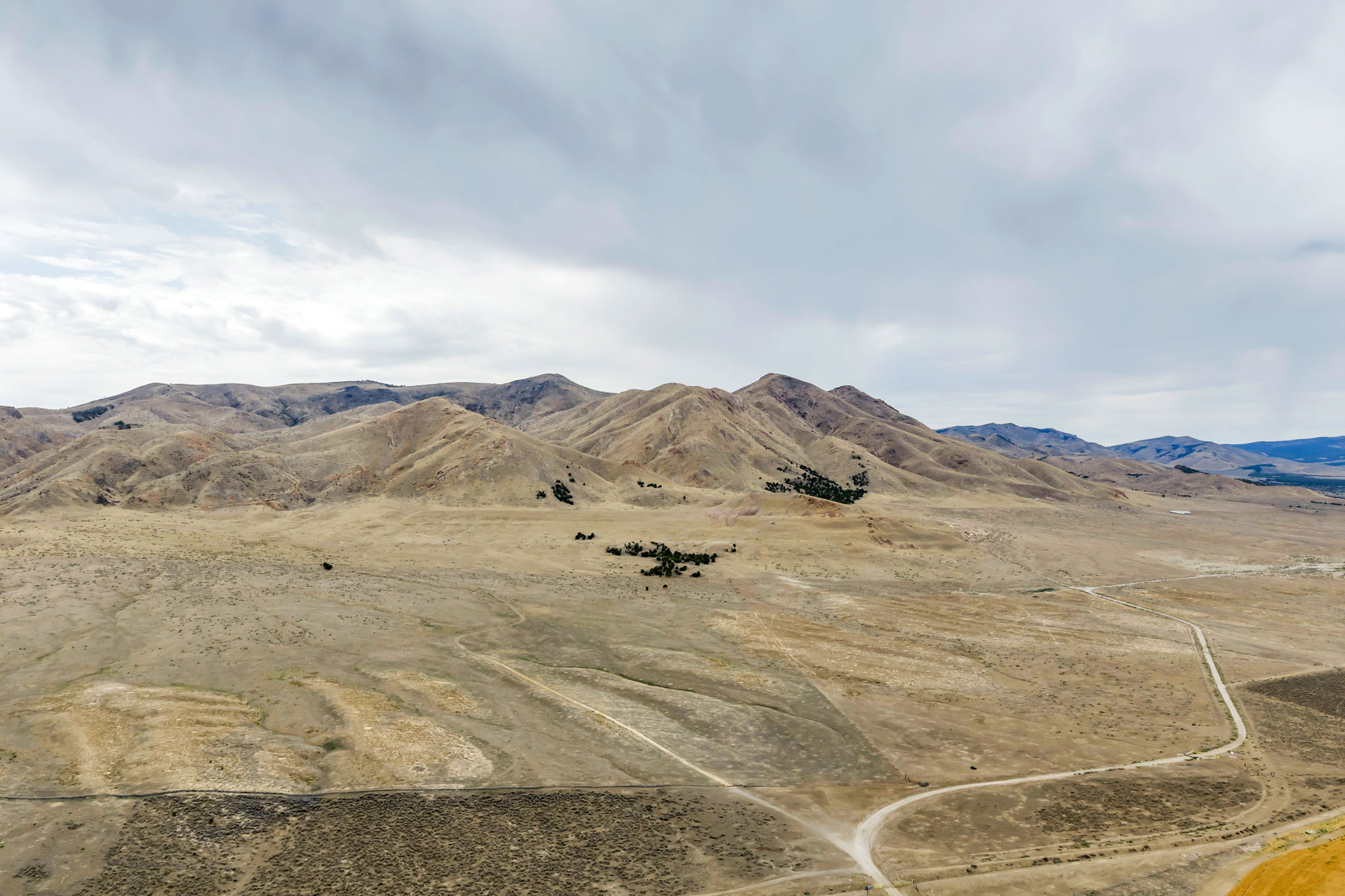 Expansive desert landscape with rolling hills and distant mountains