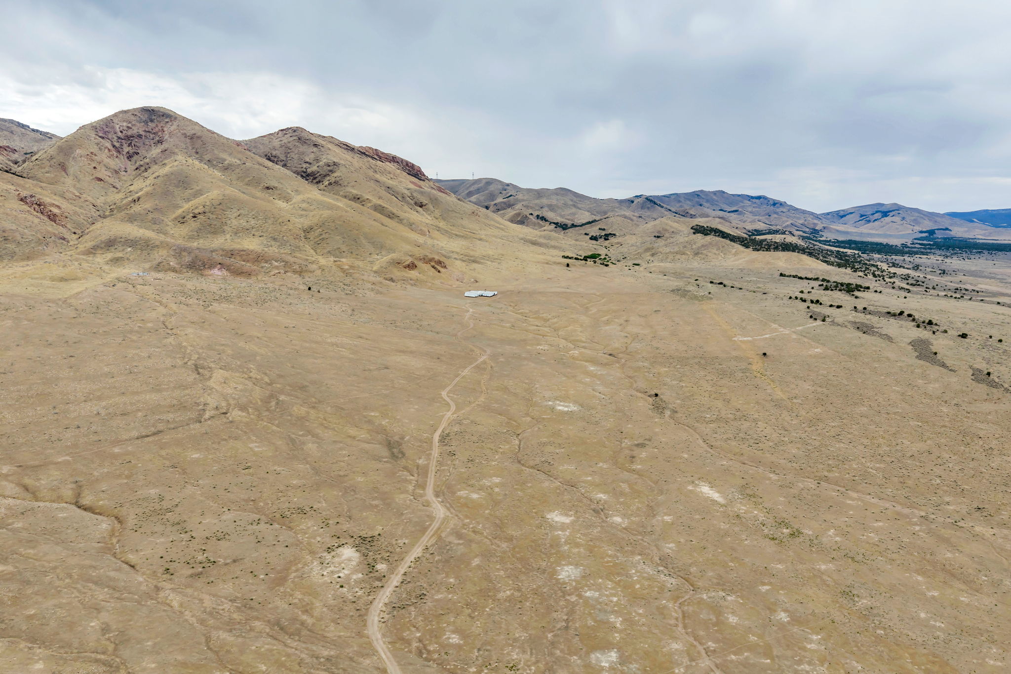 Expansive acreage featuring a white structure, distant mountains, and established trails