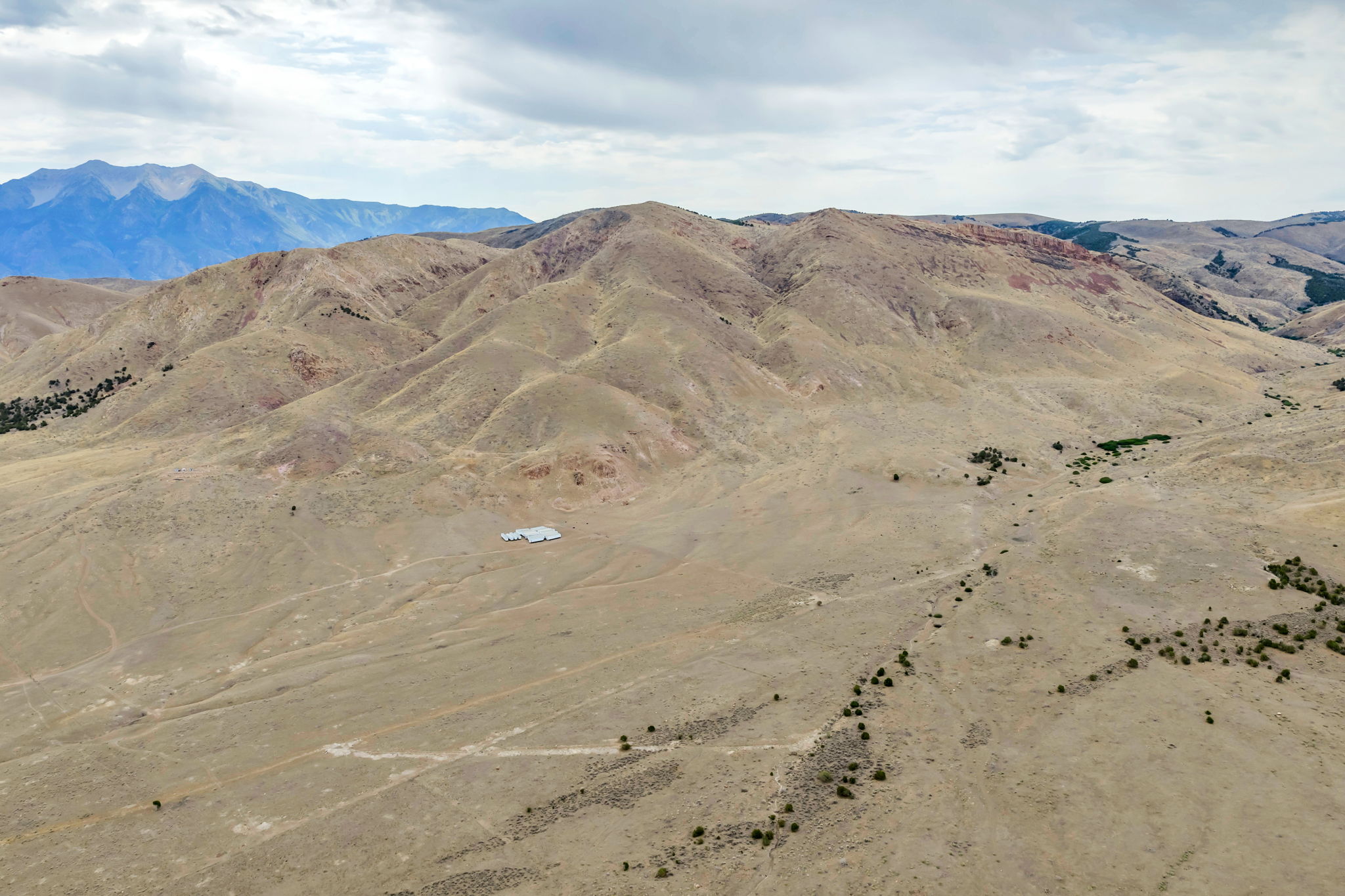 Expansive desert landscape featuring rolling hills and distant mountains