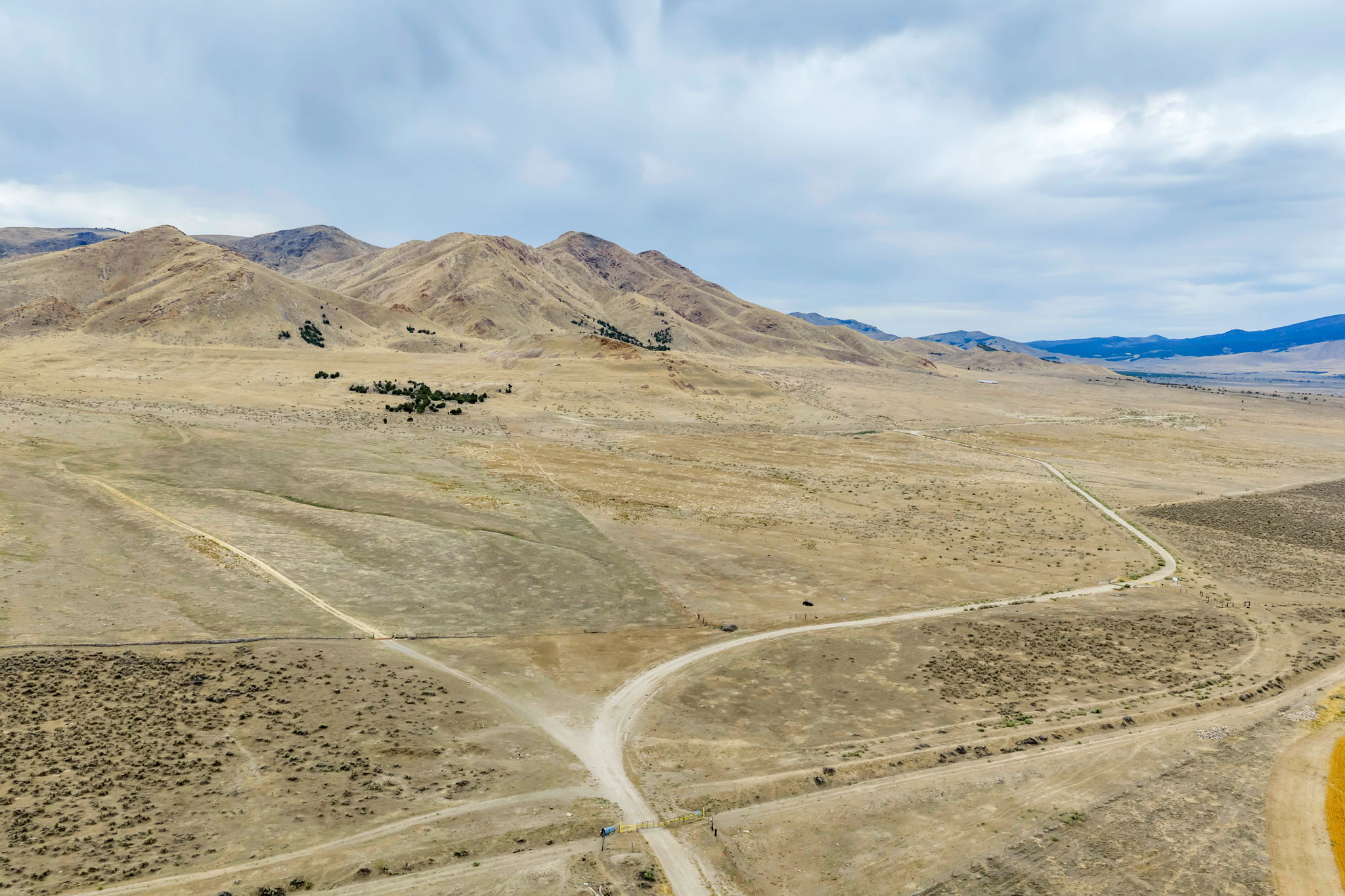 Expansive undeveloped land featuring rolling hills and distant mountains
