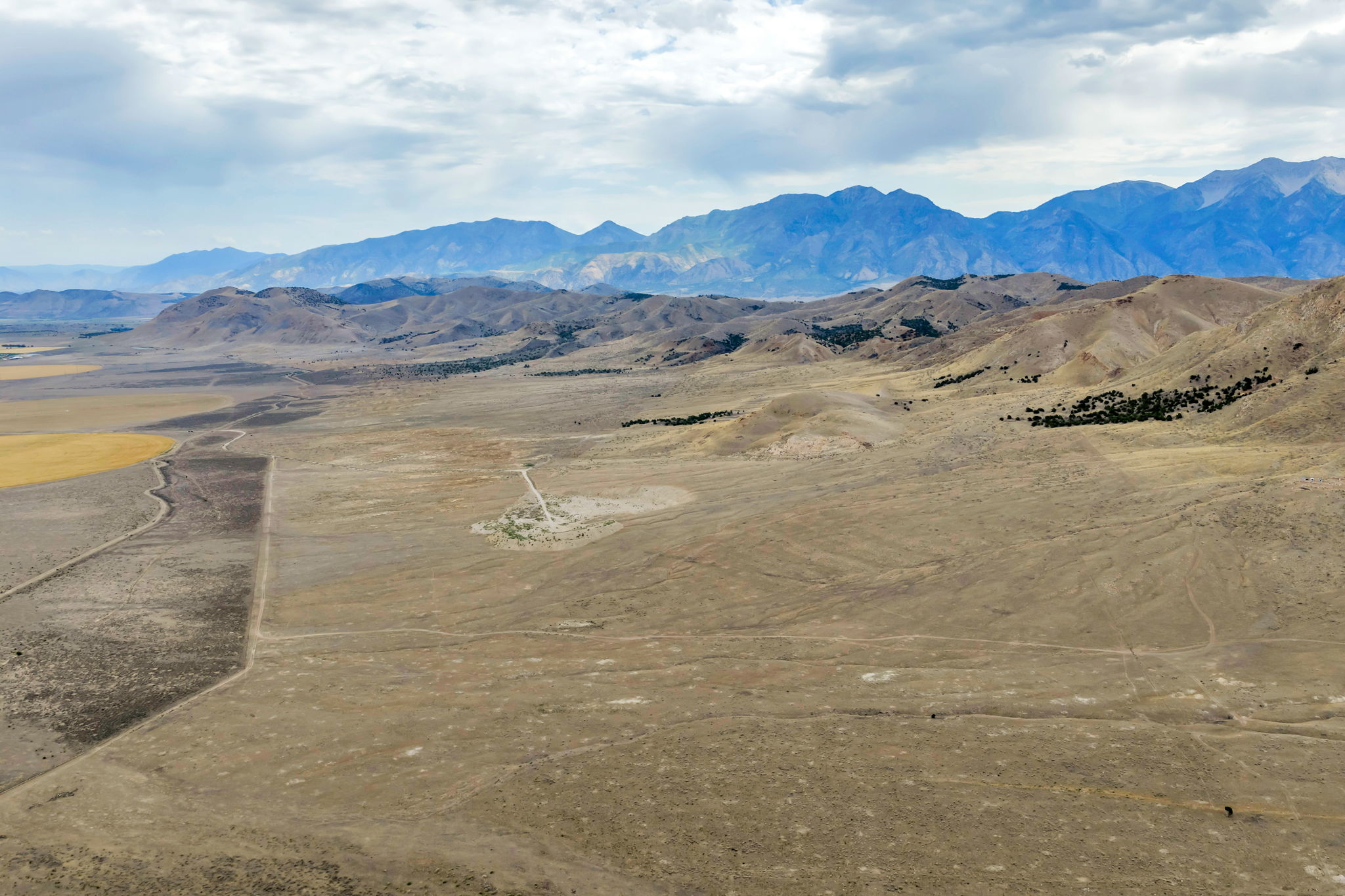 Expansive natural landscape featuring undulating terrain and distant mountain ranges