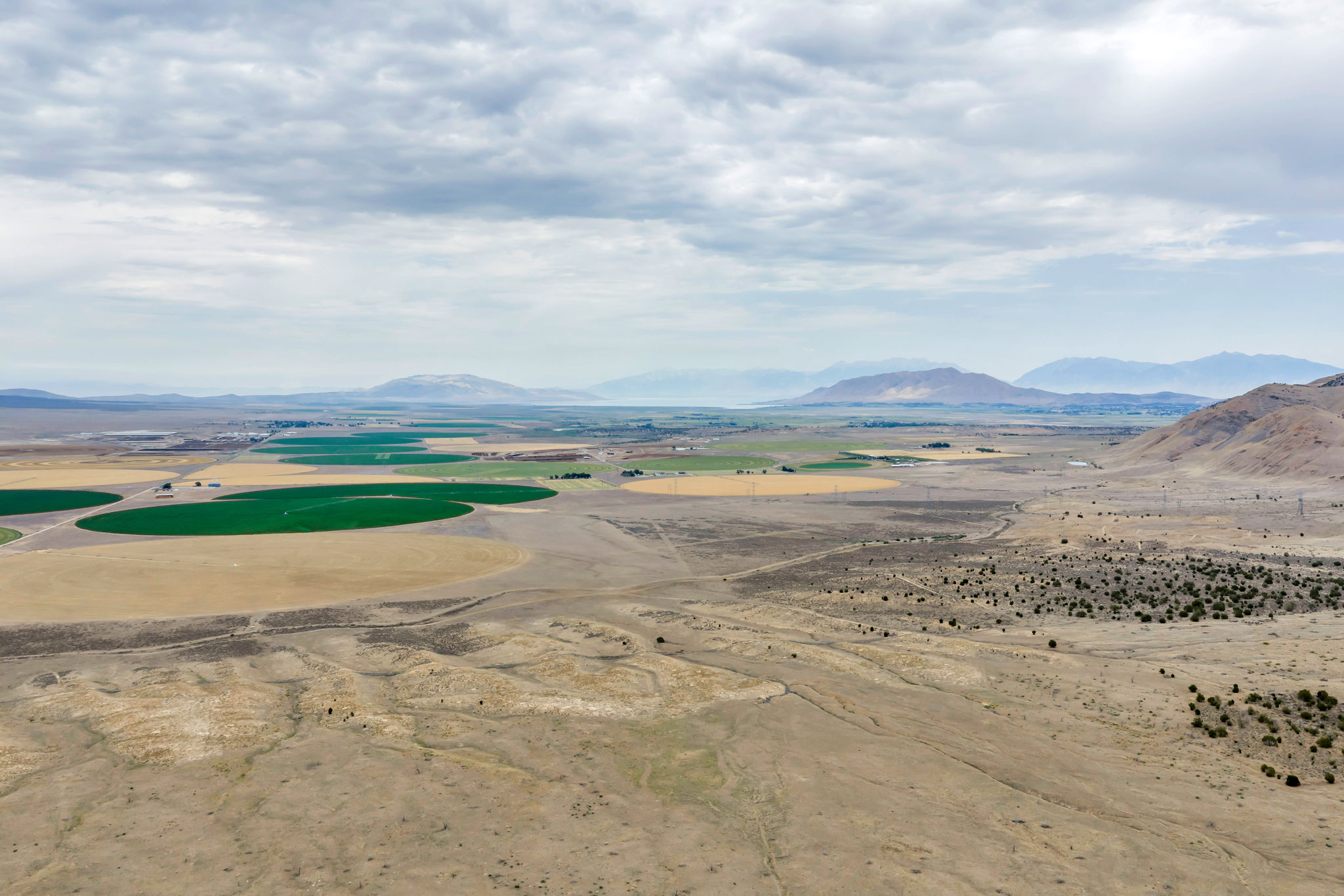 Expansive acreage featuring diverse terrain, distant mountain ranges, and agricultural fields