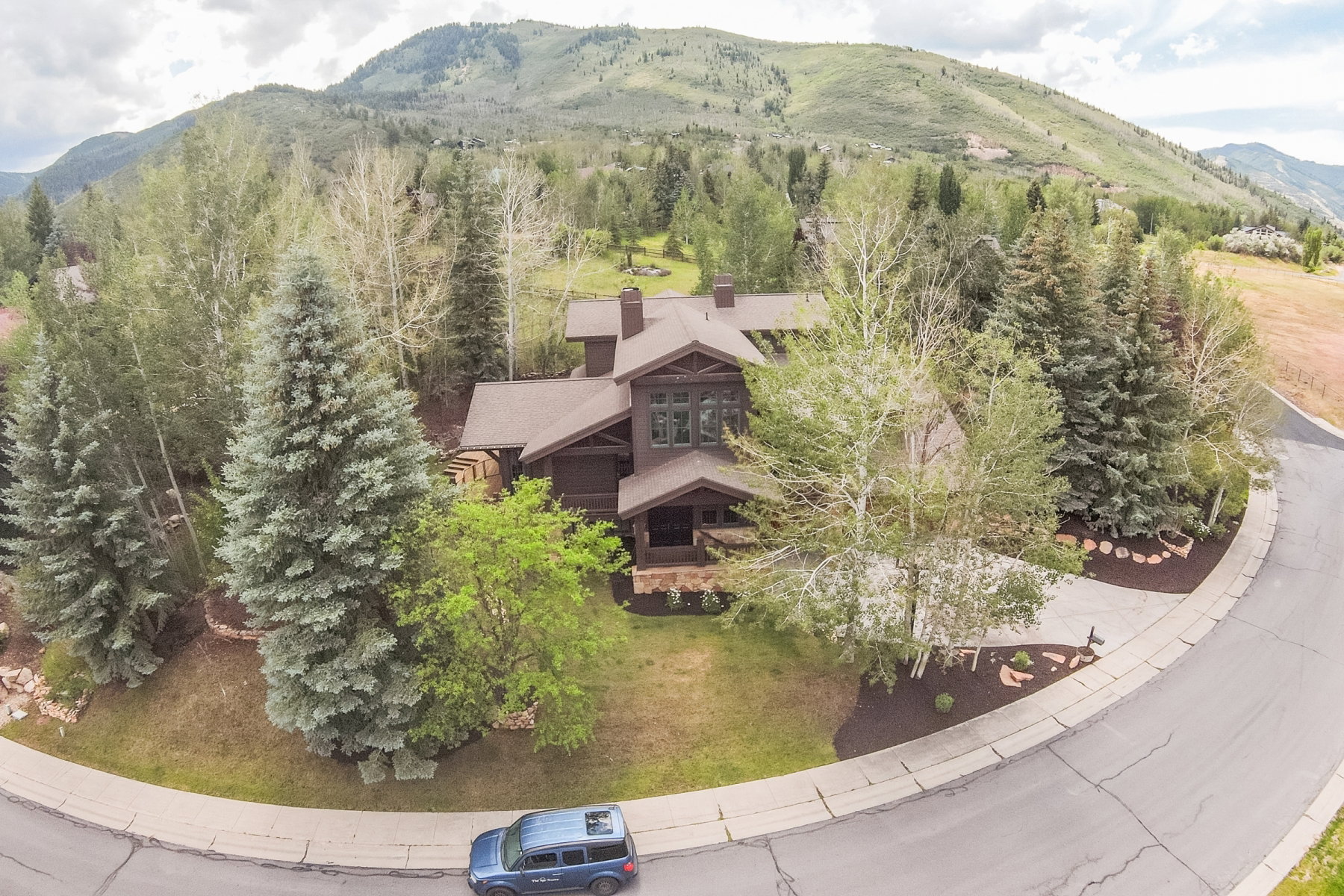 Multi-level residence featuring a dark wood exterior, a multi-peak roofline, and prominent chimney structures