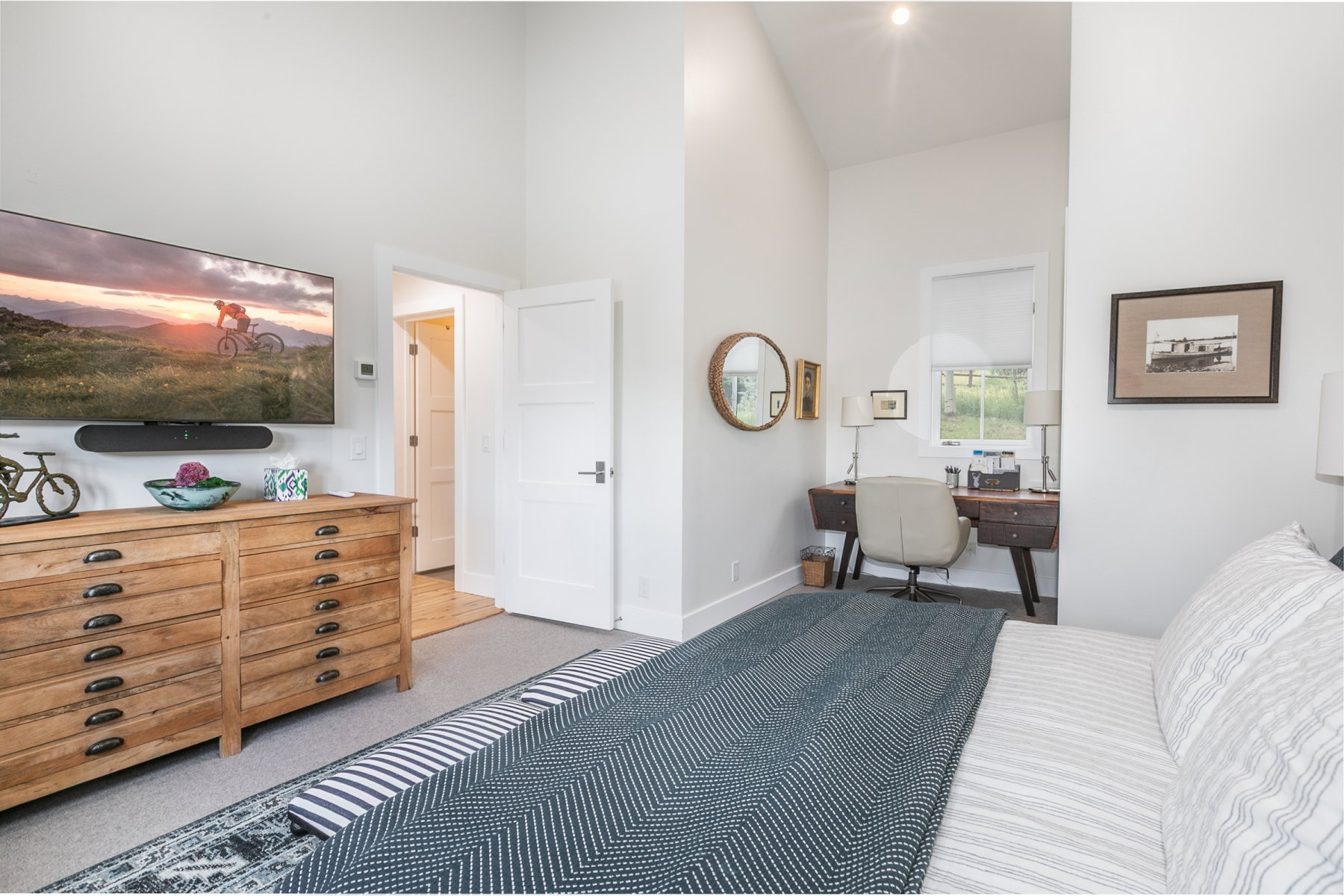 Vaulted ceilings define this interior space, featuring white walls and light-toned flooring
