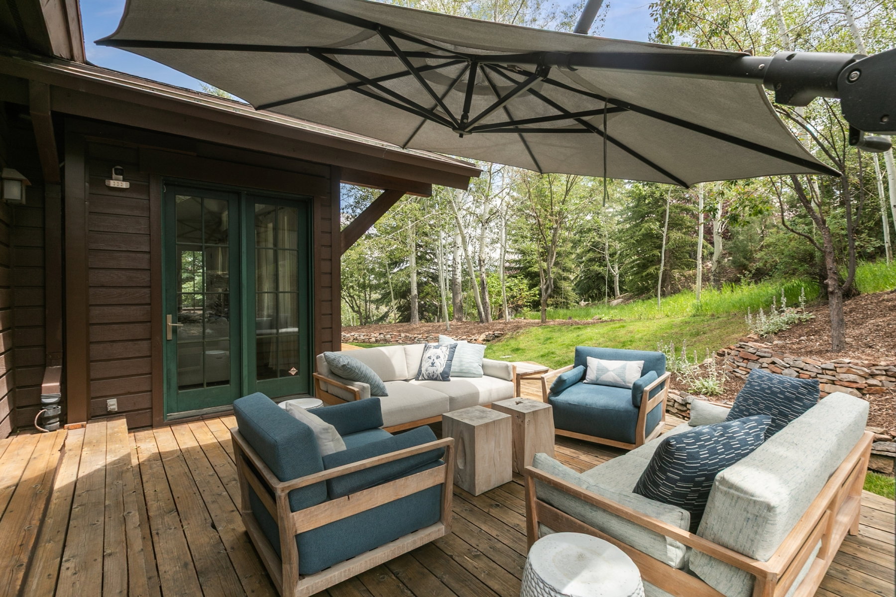 Expansive wood deck with a brown plank exterior and green French doors