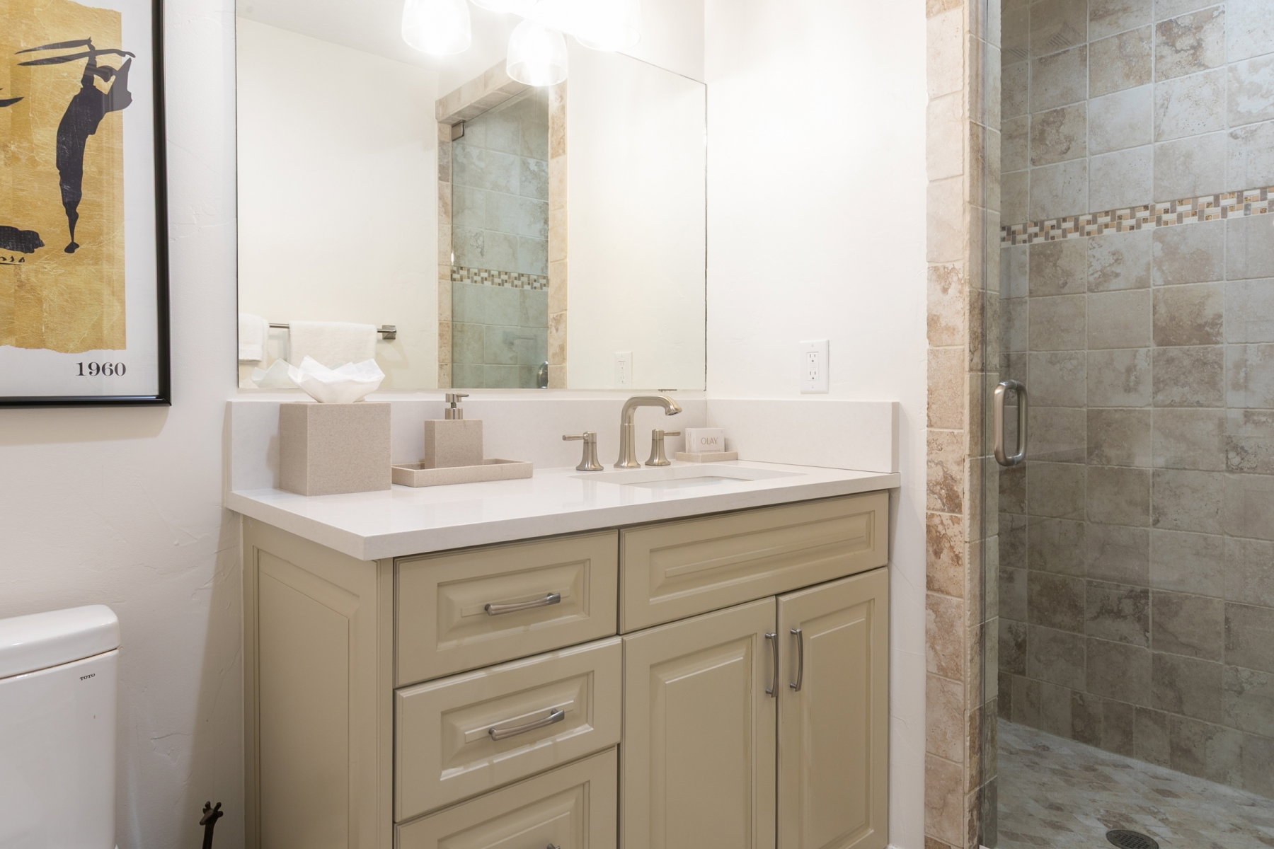 Bathroom featuring a single vanity with stone-finish countertop, brushed nickel faucet, and integrated sink