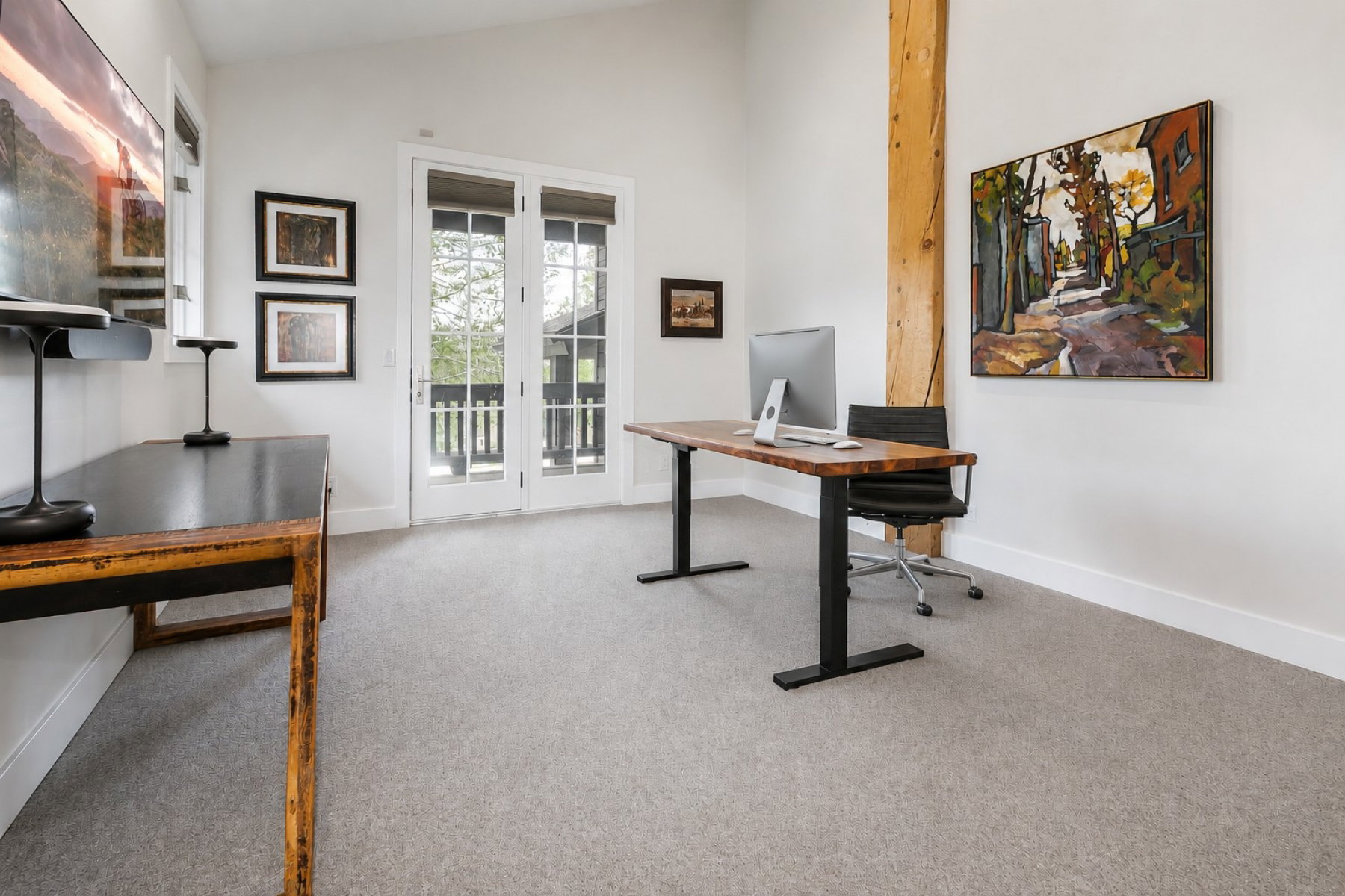 Bright room featuring double French doors with transom windows, a prominent wood structural beam, vaulted ceilings, and light-colored carpeting