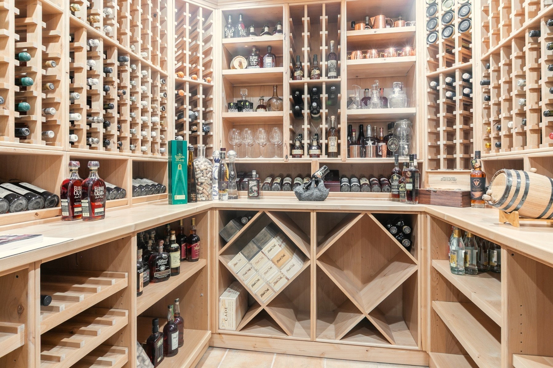 Custom wood wine cellar featuring extensive bottle storage, integrated shelving, and display countertops
