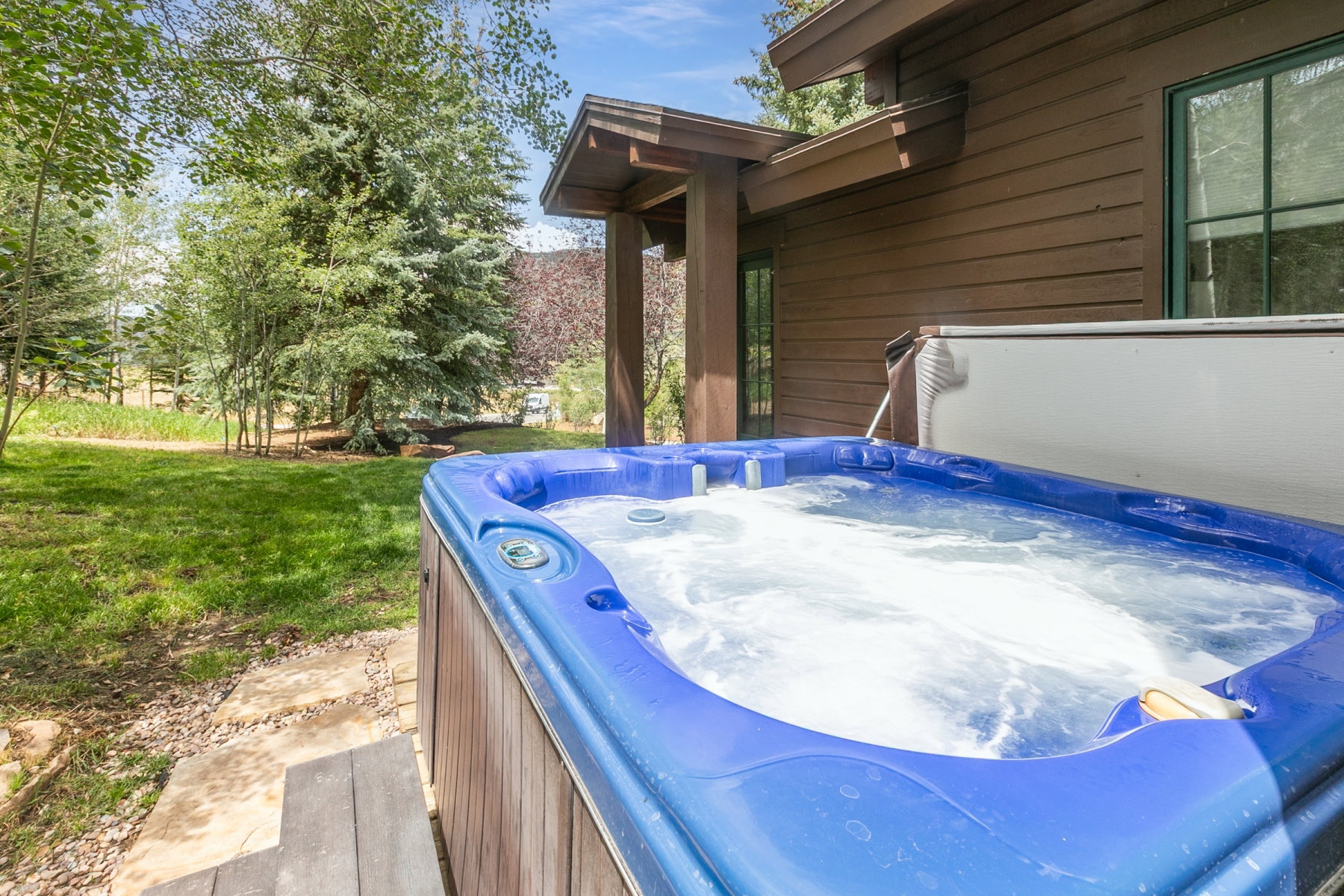 Outdoor hot tub with blue interior and wood-finish exterior paneling